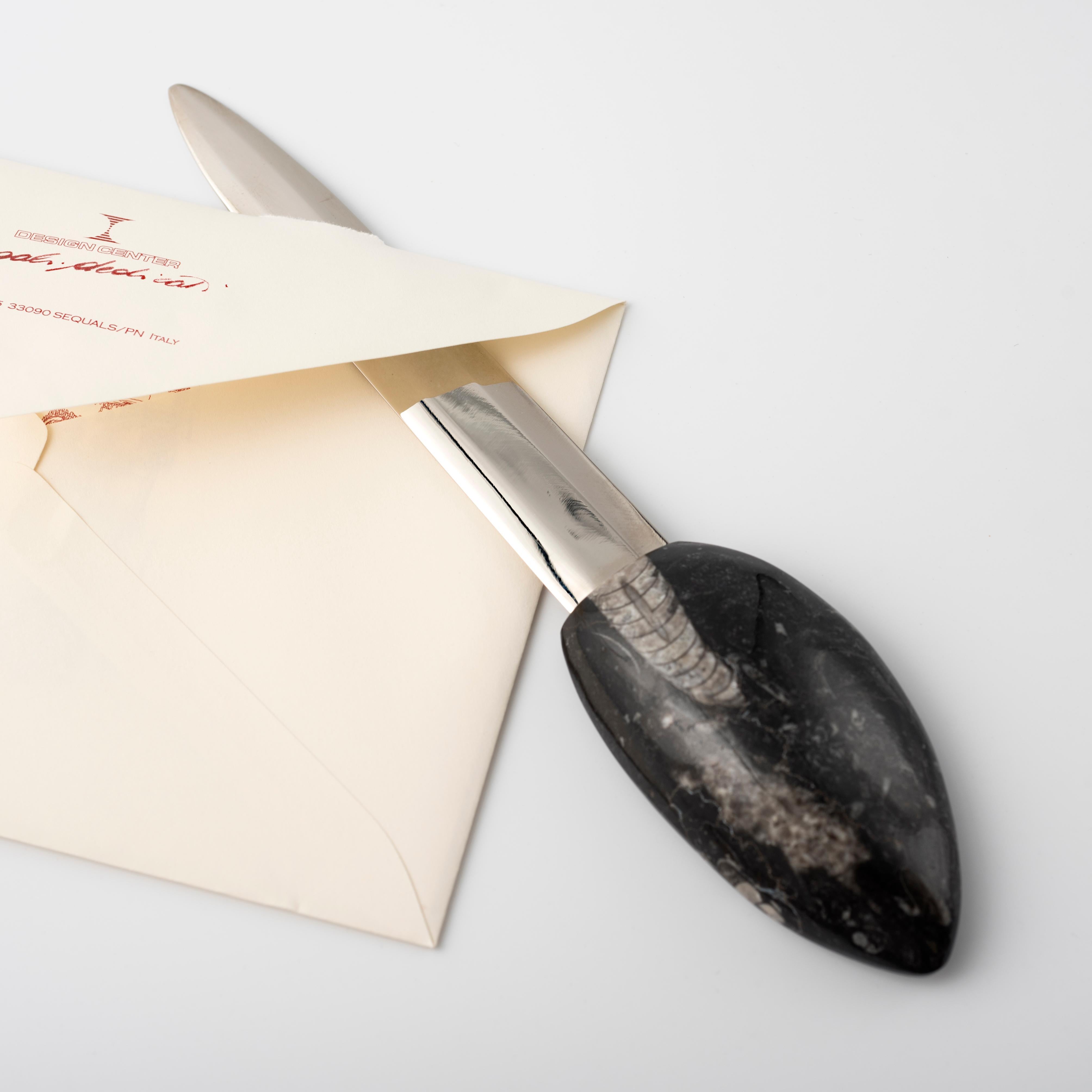 A slightly curved conical shell lying on a layer of rock becomes the unique handle of the letter opener, a must-have desk accessory.
Designed by Nino Basso, the designer of the Fossiline one-of-a-kind pieces collection, the letter opener features a
