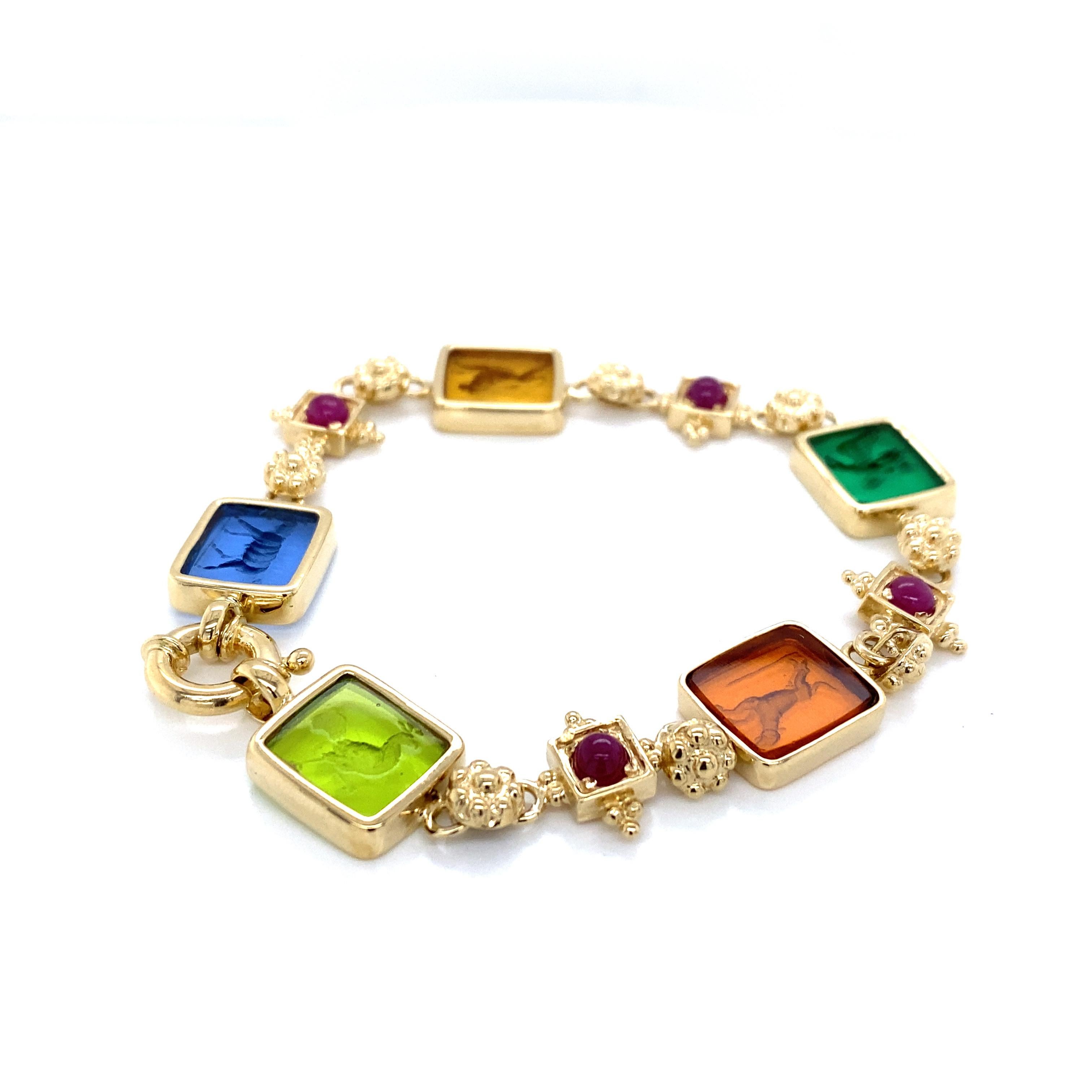 Tagliamonte Ruby Colored Venetian Glass Bracelet in 14K Yellow Gold.  (4) Ruby Gemstones weighing 1.0 carat total weight are expertly set in stations between the colored etched bezel set glass.  The Bracelet measures 7 1/2 inch in length and 1/2