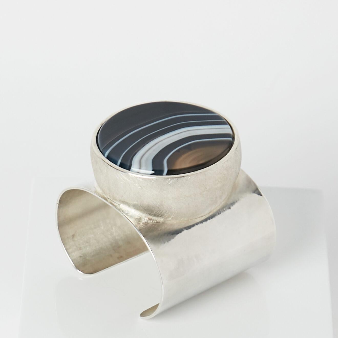 Taher Chemirik’s Edith Cuff is crafted from silver and features a wonderful agate. The one-of-a-kind piece was created exclusively for Objet d’Emotion.

Taher Chemirik’s creations have the beauty of a functional sculpture: dense as well as sensual,
