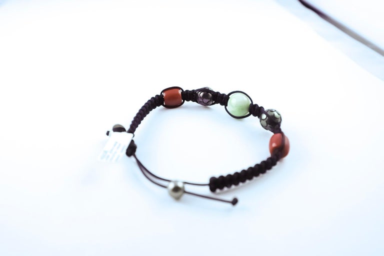 Upgrade your everyday accessories with this lovely versatile handmade bracelet.
Tahiti pearls,  jade, coral and a white gold 18K charm are threaded onto black makramee.
Suited to any occasion and any attire, we brought this very unique and latest