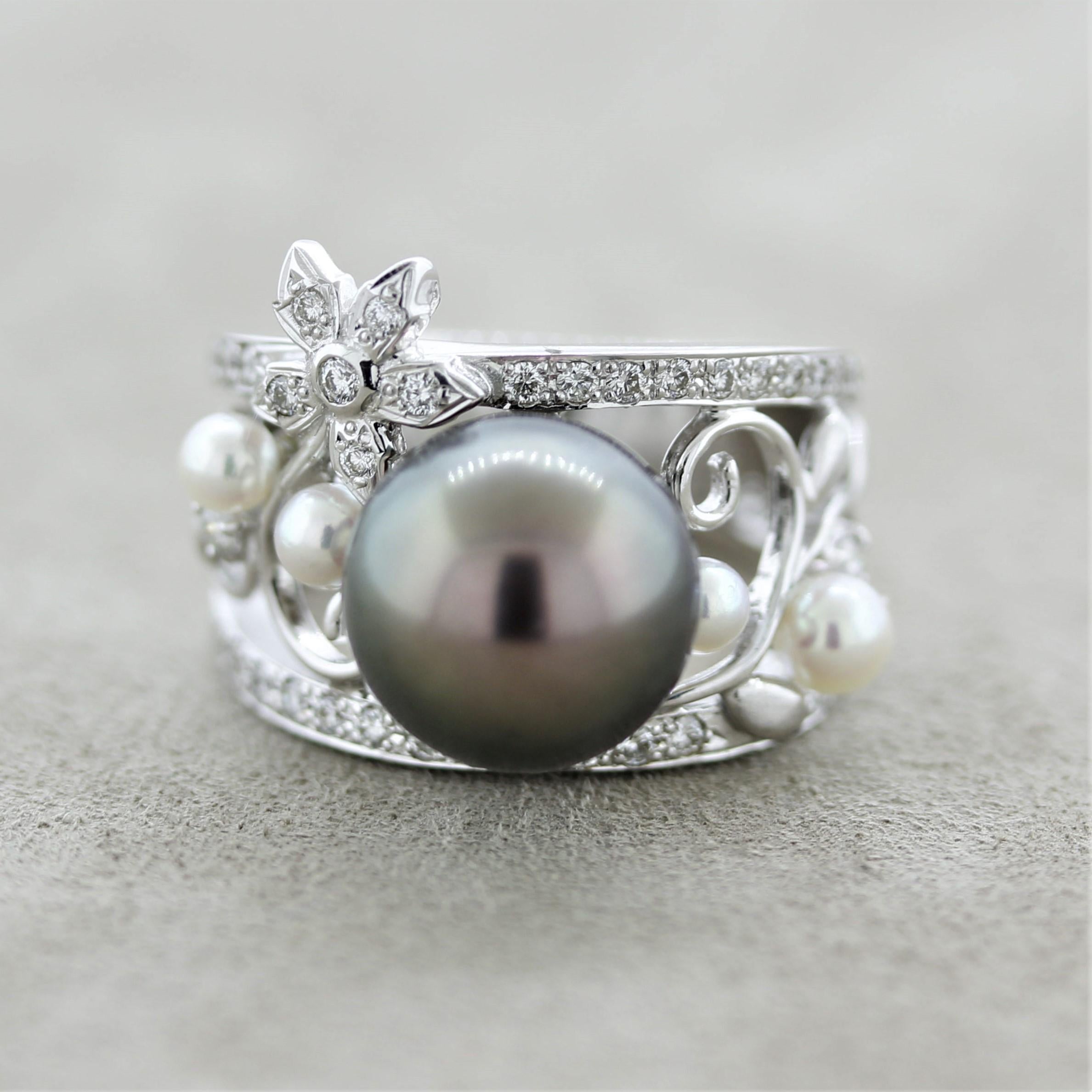 A lovely ring featuring a large and fine quality Tahitian pearl measuring 11.3mm. It has a rich iridescent black pistachio color and is perfectly round with close to no visible blemishes. Adding to that are 4 smaller akoya pearls with very fine