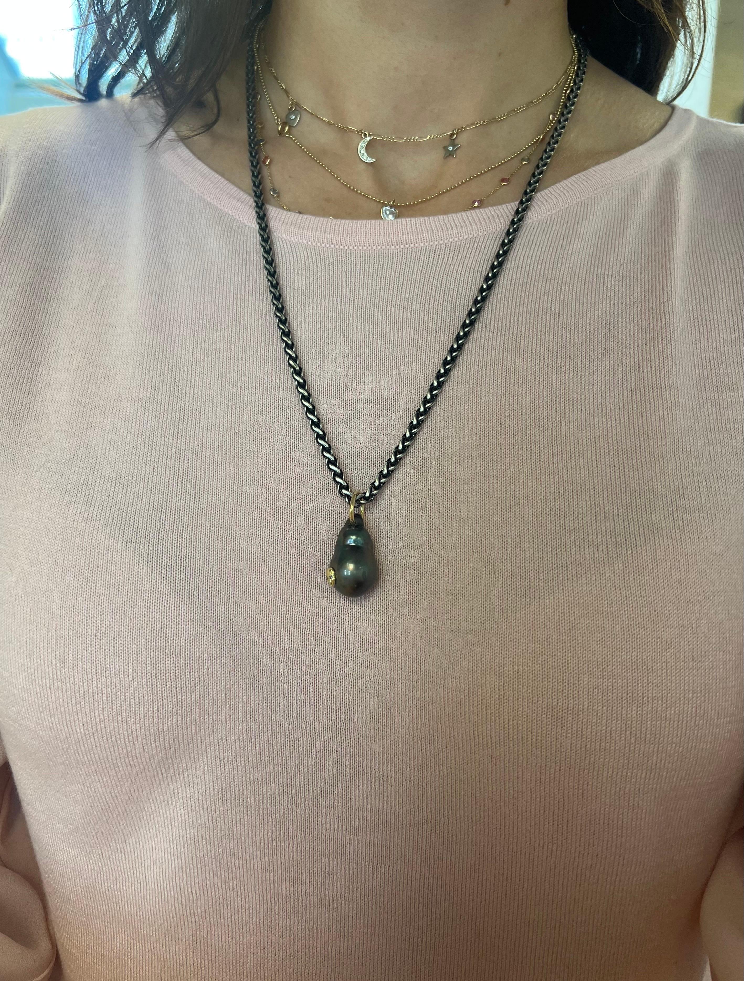 Introducing a captivating fusion of edgy elegance and natural allure, our Tahitian Black Baroque Pearl Pendant Necklace is a true embodiment of unique beauty. Suspended gracefully on a ruthenium plated sterling silver chain, this exquisite pendant