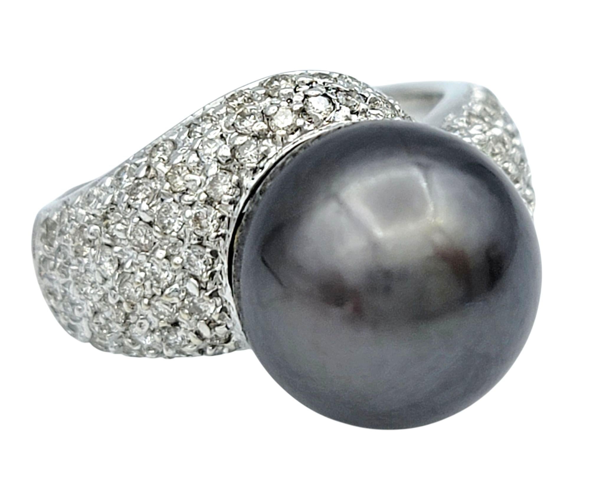 Misura dell'anello: 5.25

Questo accattivante anello di rappresentanza mette in mostra una straordinaria perla coltivata nera come elemento centrale. La perla è cullata in un'audace montatura che si apre a ventaglio, incrostata di scintillanti