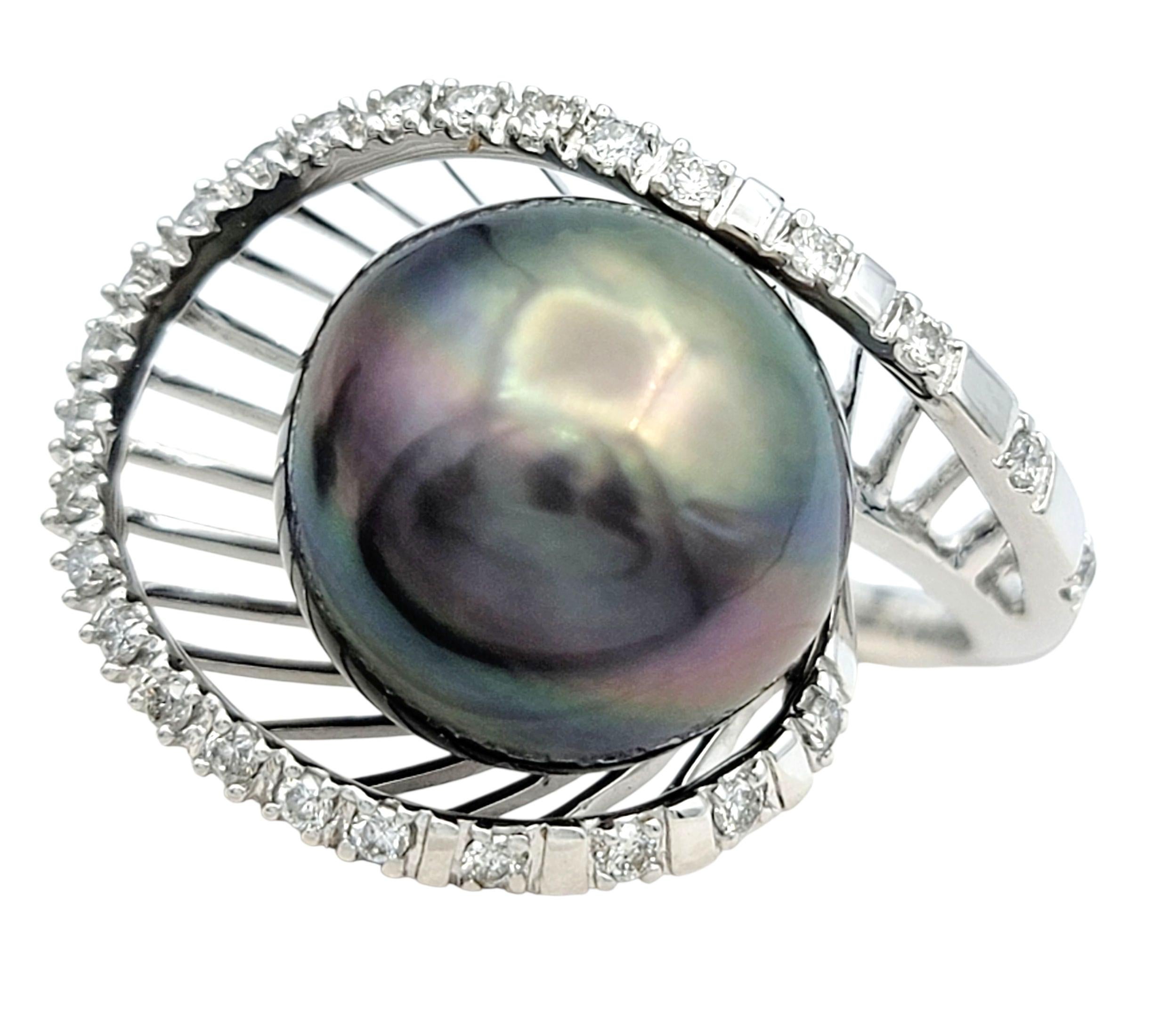 Questo elegante anello presenta una straordinaria perla di Tahiti, la cui lucentezza profonda e iridescente emana una raffinatezza senza tempo. La grande perla è splendidamente incorniciata da scintillanti diamanti rotondi taglio brillante, creando