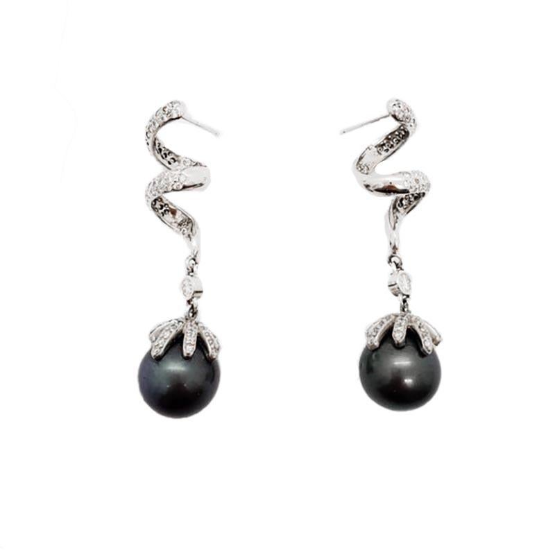 14K white gold dangle diamond pave earrings featuring two large Tahitian black pearls. There are 1 carat of white eye clean round brilliant diamonds. Handmade in 14k white gold. 

