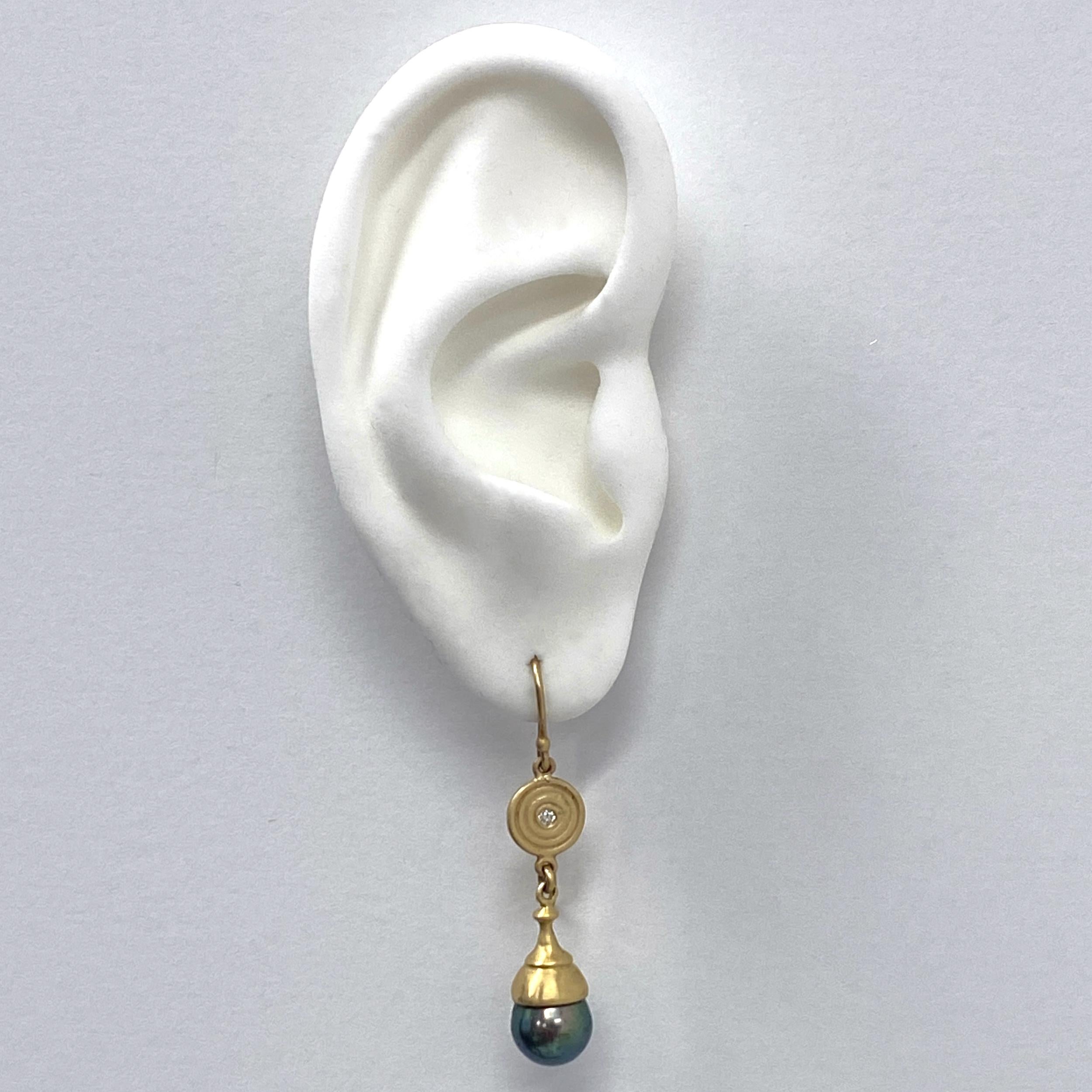 Diese wunderschönen, verspielten Ohrringe von Eytan Brandes bestehen aus zwei kleinen (8,5 - 9 mm) Tahiti-Perlen, die eine absolut verrückte Farbe haben - tiefes Pfauengrün mit violetten Untertönen.

Eytan hat die Kappen speziell für die Perlen