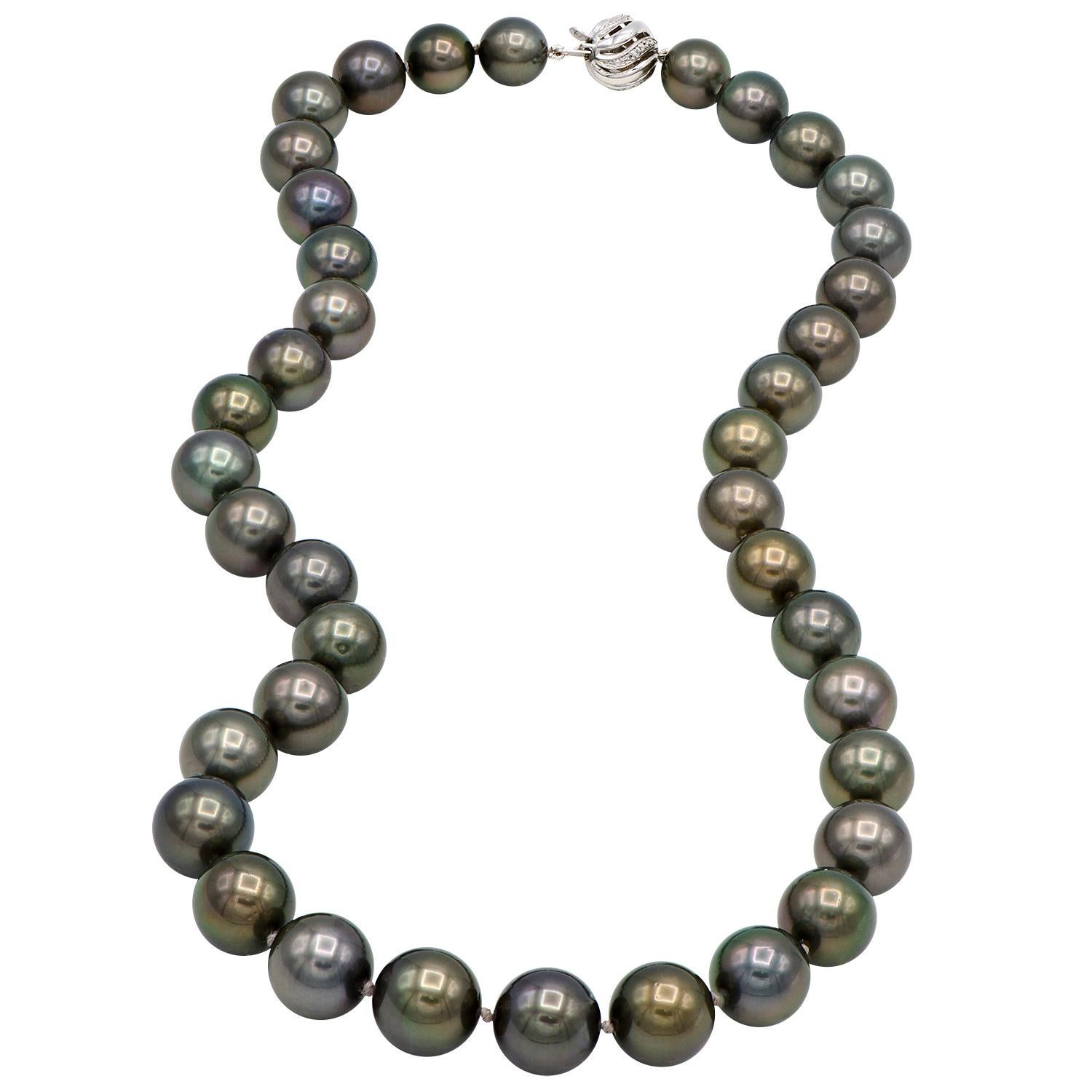 This beautiful black Tahitian pearl necklace is made from 39 pearls sizes 9.2-11.6mm. These darker black pearls make an 18 inch strand which is expertly strung with a double know in between each pearl and is closed with a 14 karat white gold ball
