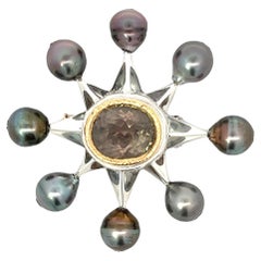 Broche étoile de Tahiti en or, argent et platine avec perles noires et tourmaline grise