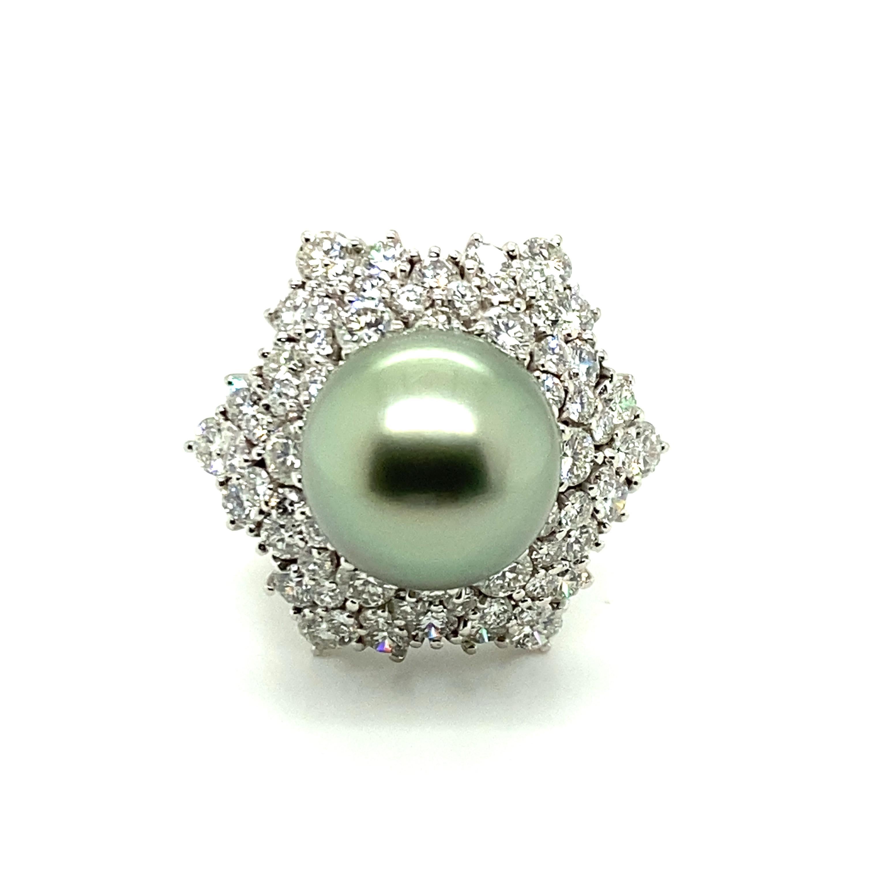 This beautiful ring in platinum 950 features a fine Tahitian cultured pearl of 14.0 mm in diameter. Round and clean, this mesmerising cultured pearl shows a unique pistache color with a soft shimmer. 
The star-shaped entourage is set with 68