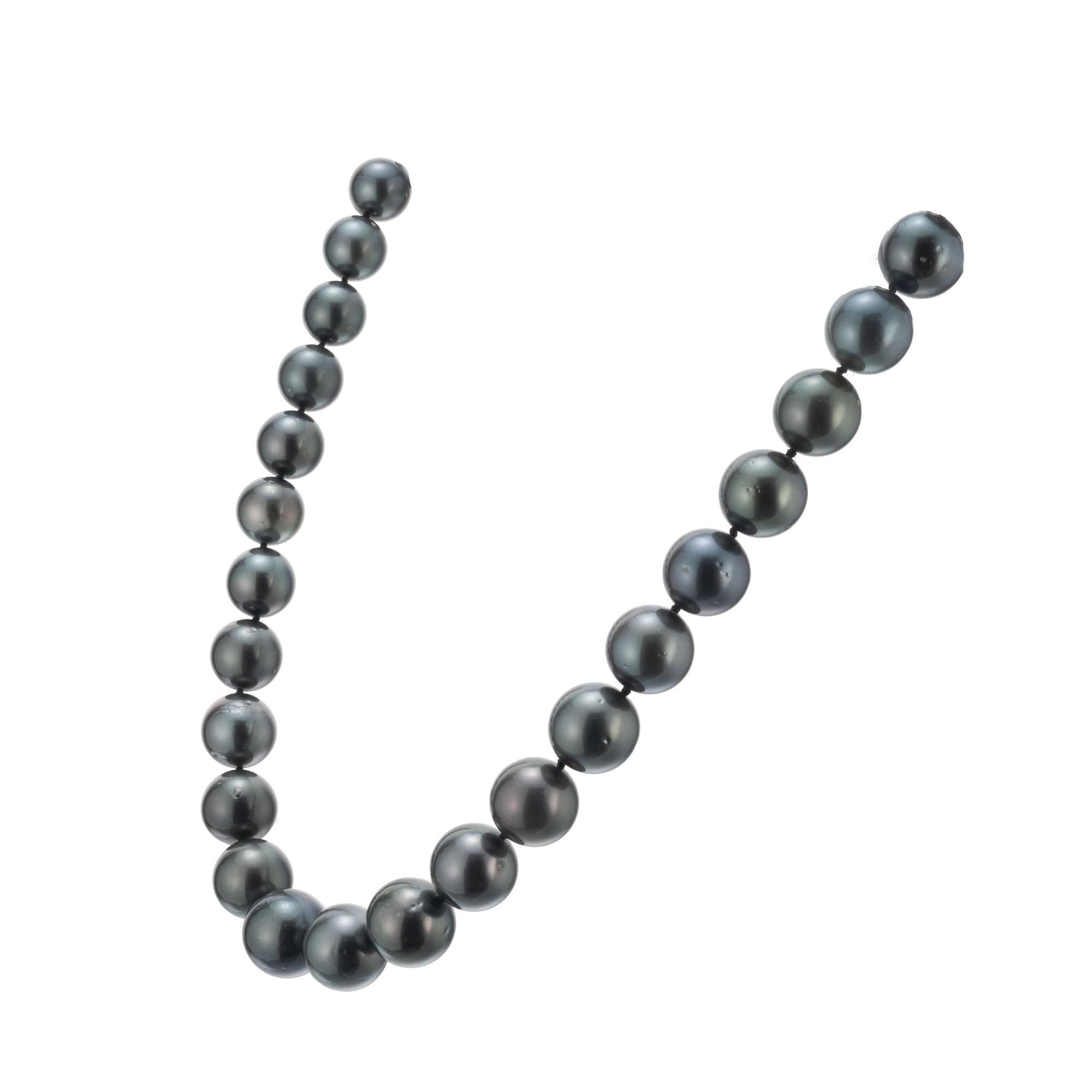 Graduating Tahitian pearl necklace. 18 Inch necklace of Tahitian pearls graduating from 11mm to 14.6mm at the center with an 18k yellow gold corrugated ball clasp. Good Lustre, well matched, few to moderate blemishes.

33 Tahitian black pearls, 11mm