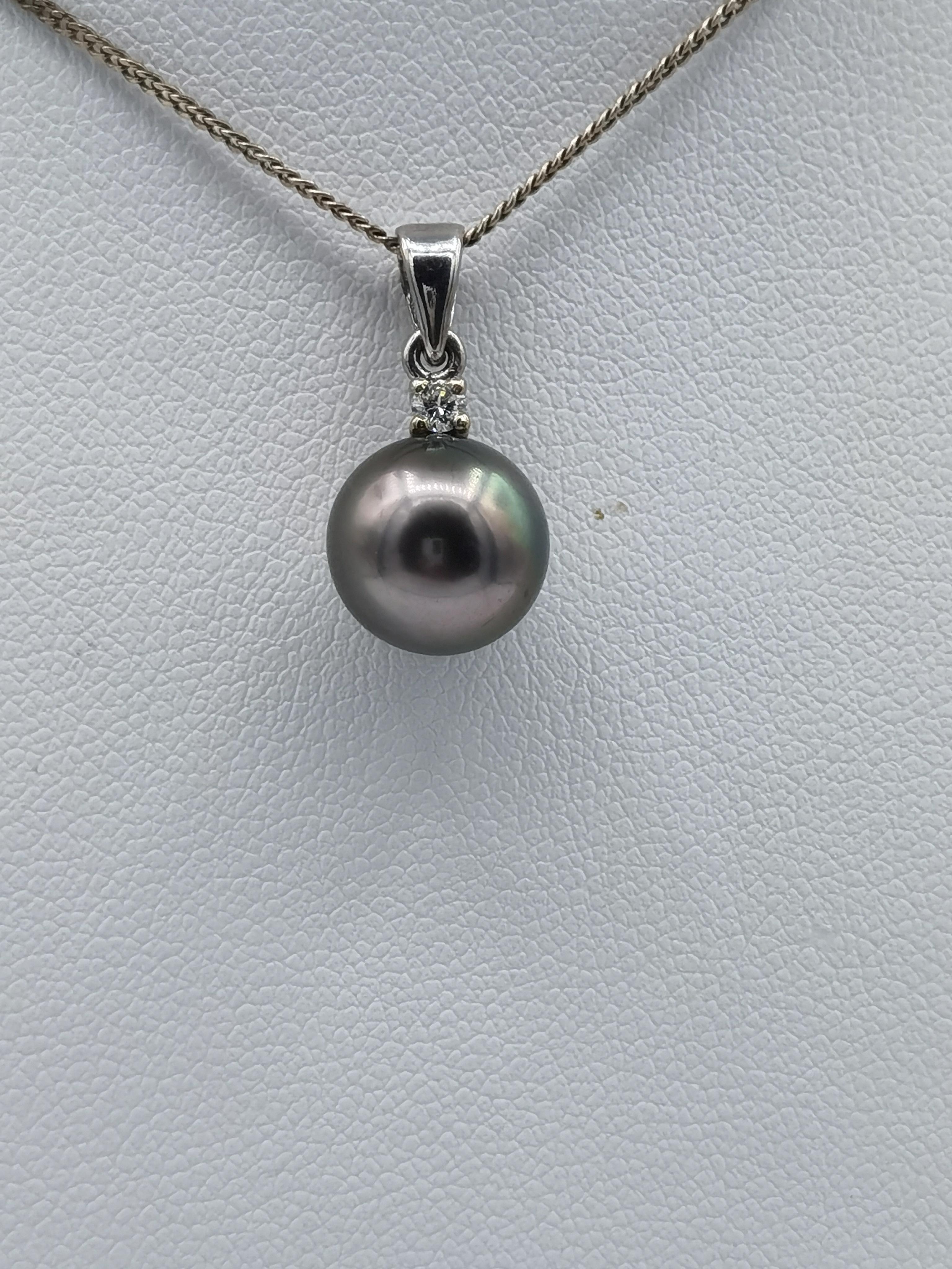 This pendant has a 8 mm round Tahitian gray pearl on top 
1 diamond 0,05 ct all set in 18 k white gold
weight is 2 gram
long 18 mm