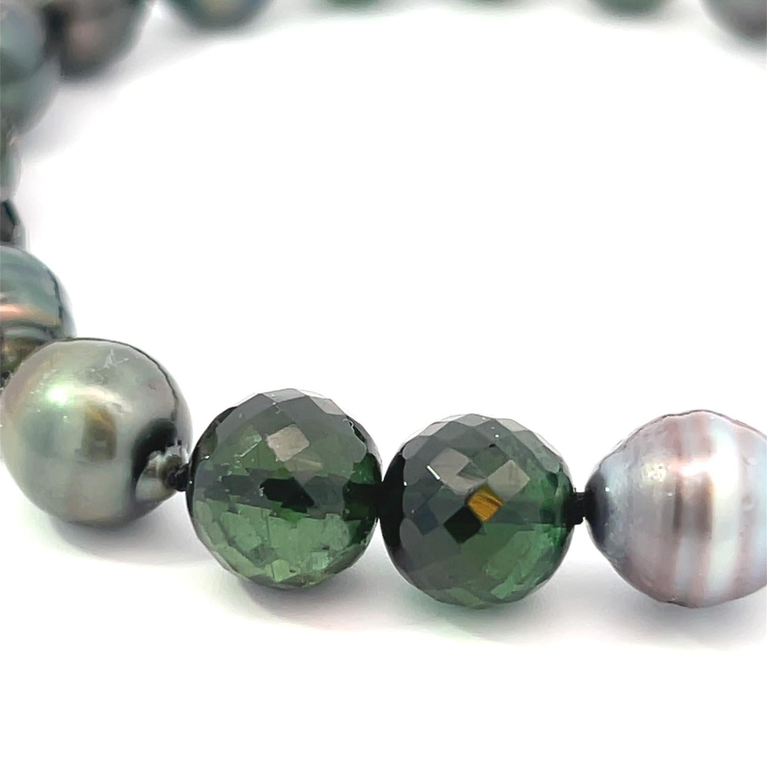 Elevate your jewelry collection with this exquisite Black & Gray Baroque Tahitian Pearl and Black/Green Tourmaline Beaded Bracelet. Showcasing the natural beauty of 8-10mm baroque Tahitian pearls, each piece is uniquely shaped, displaying