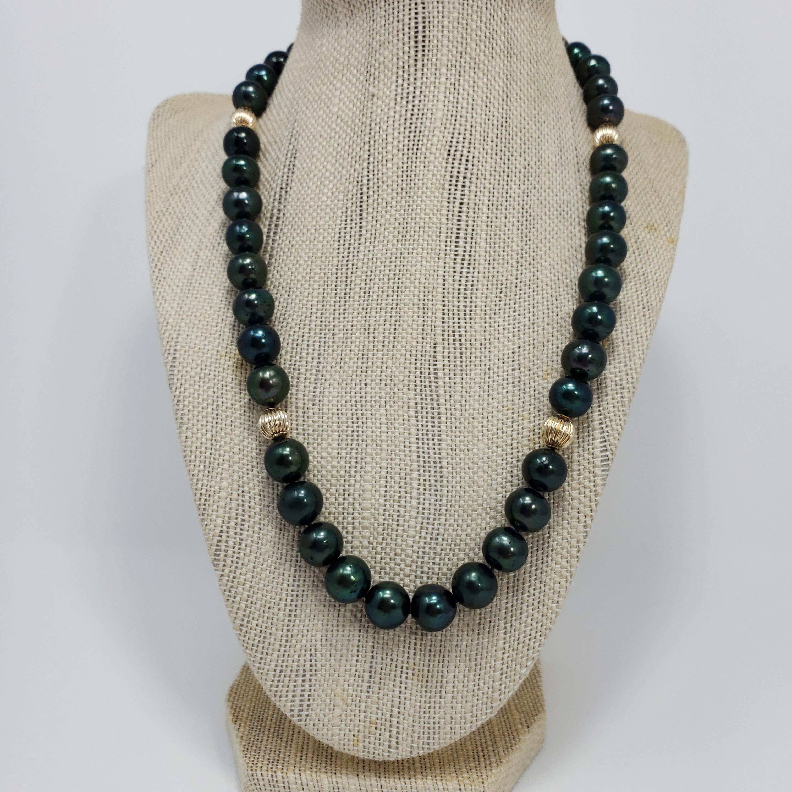 A sophisticated Tahitian pearl necklace. This strand of tahitian pearls has a luxurious green tint and is decorated with 14K yellow gold accents and clasp. A perfect accessory to top off any style!

Hallmarks: 14K
Beads range from approximately