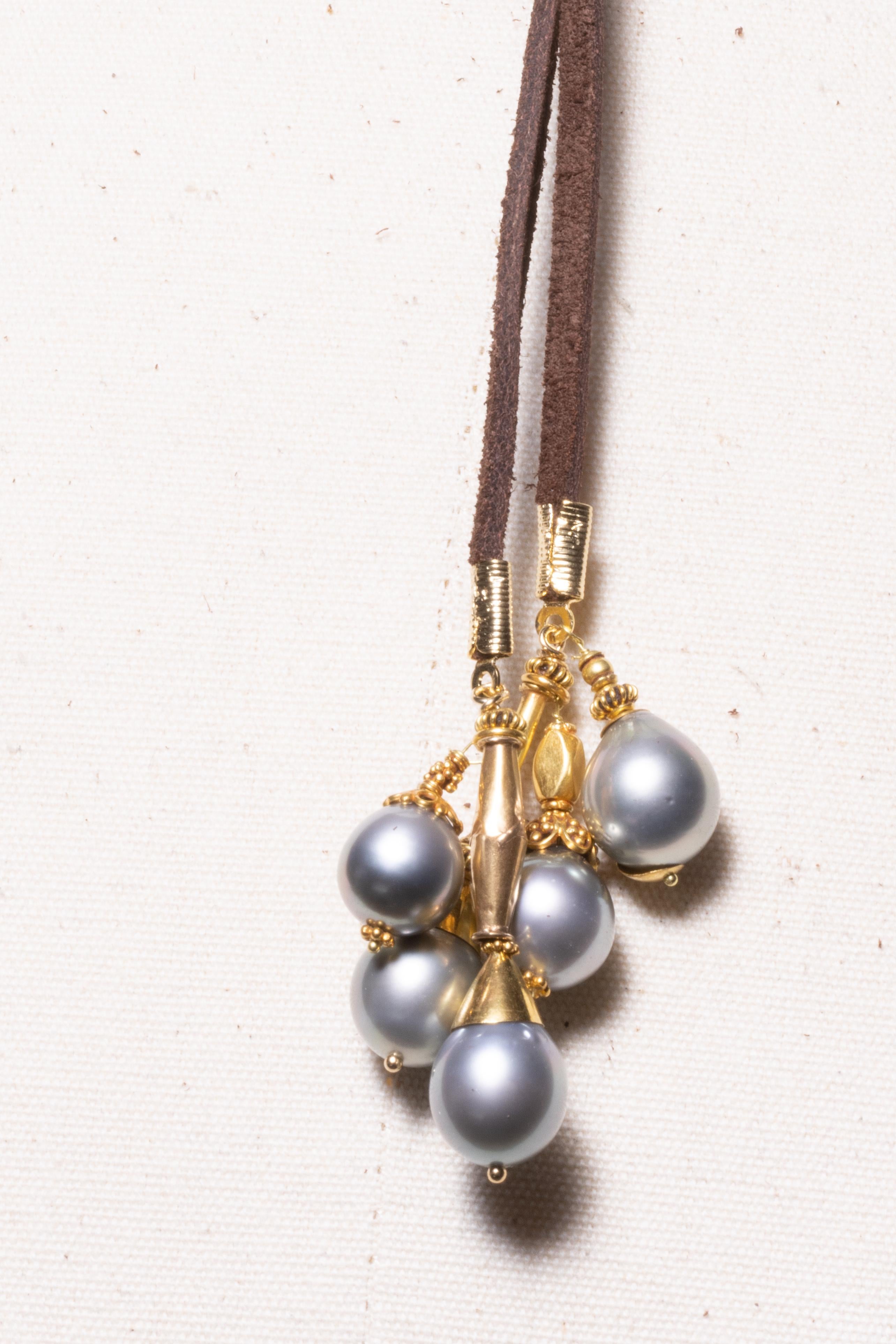 A very versatile and sexy suede lariat necklace with a cluster of Tahitian pearls and 18K gold.  Five tahitian pearls of various shapes and sizes, and beautifully hand tooled and granulated goldsmith work.  Double it and wear it short, or loop it