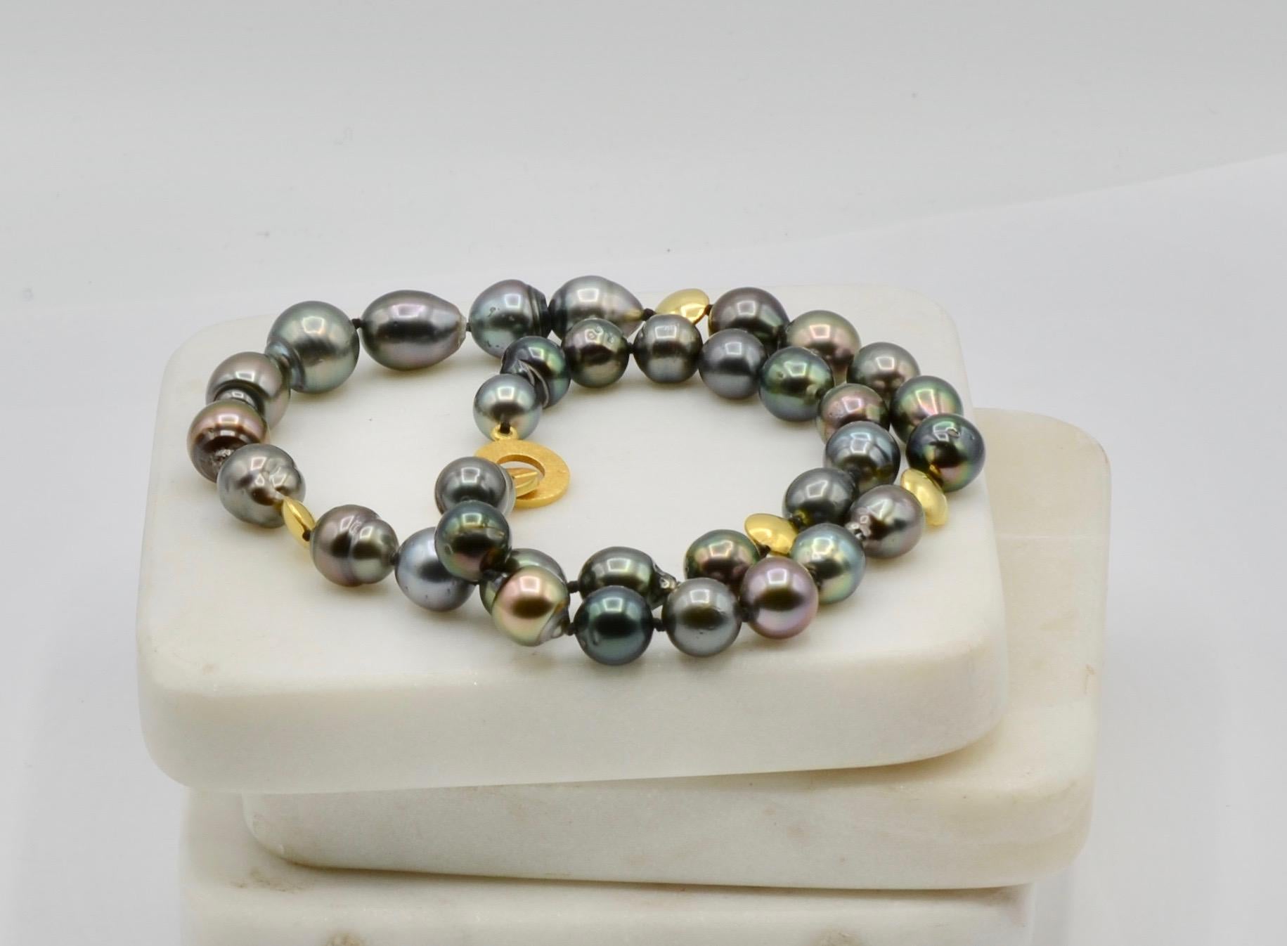 These deep blue Tahitian pearls have a rainbow luster that is mesmerizing. The 18 karat beads and clasp add a beautiful accent of color. The 18 inch length is the perfect length. 