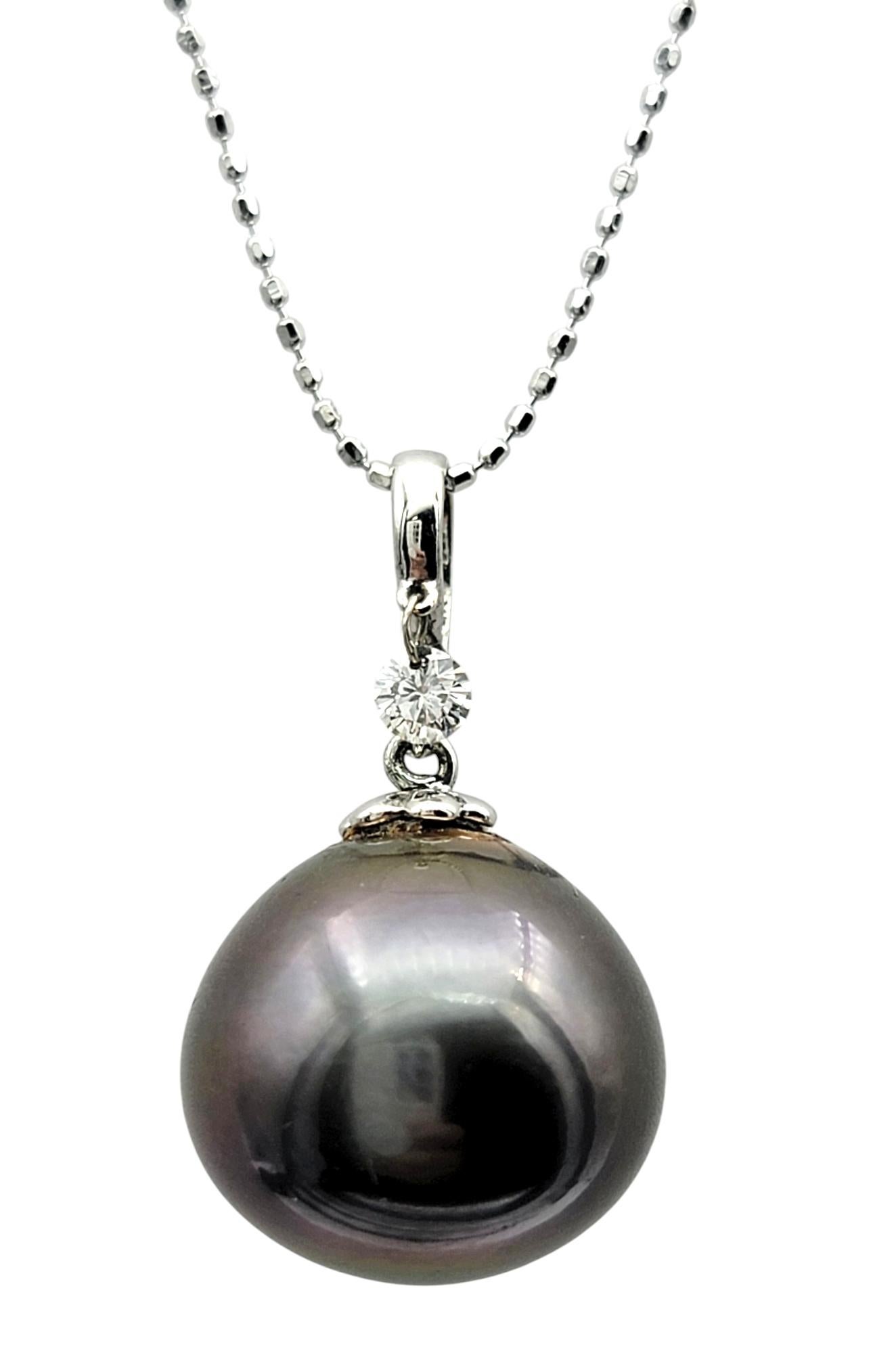 Embrace elegance with this stunning Tahitian pearl and diamond dangle pendant necklace, crafted in luxurious 18 karat white gold. The centerpiece of this exquisite piece is a luminous cultured Tahitian pearl, celebrated for its deep, iridescent hues