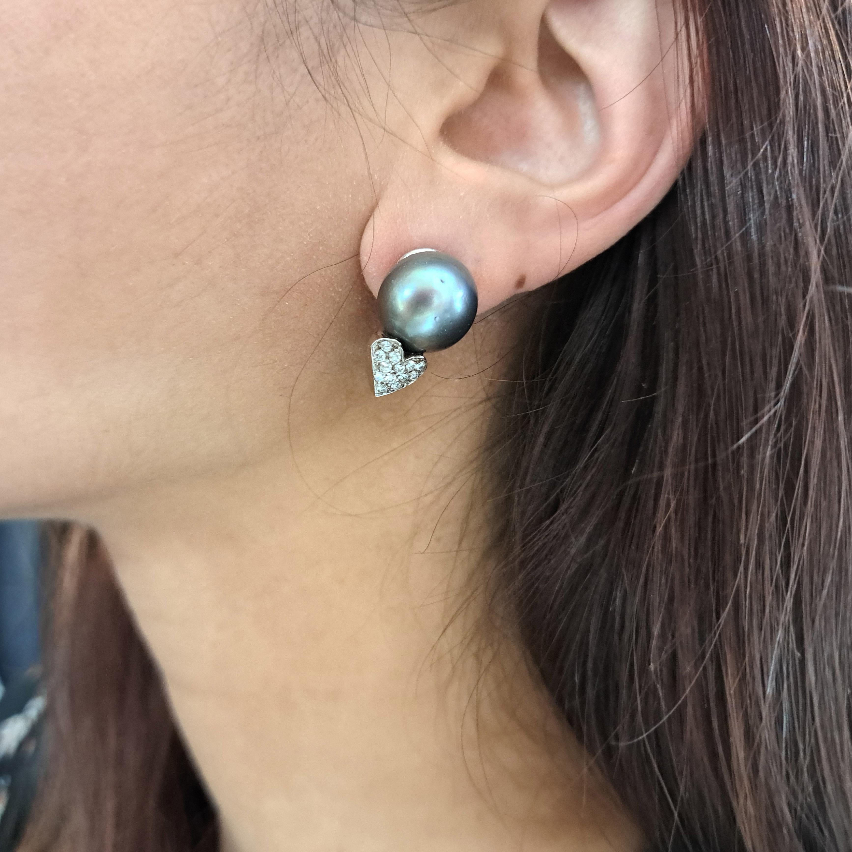 A pair of Tahitian pearl and diamond earrings, with approximately 13mm to 13.5mm Tahitian pearls, each with a pavé set diamond heart below, mounted in 14ct white gold, with butterfly backs. Circa 1990.