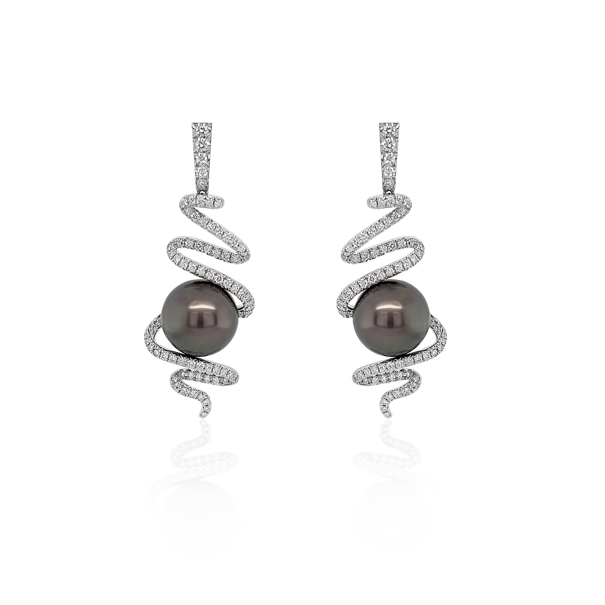 This exquisite pair of earrings embodies elegance and originality. These earrings showcase a mesmerizing spiral design, meticulously encrusted with natural diamonds and at the heart of the earrings lie a 13mm Tahitian Pearl. All set in 18k white