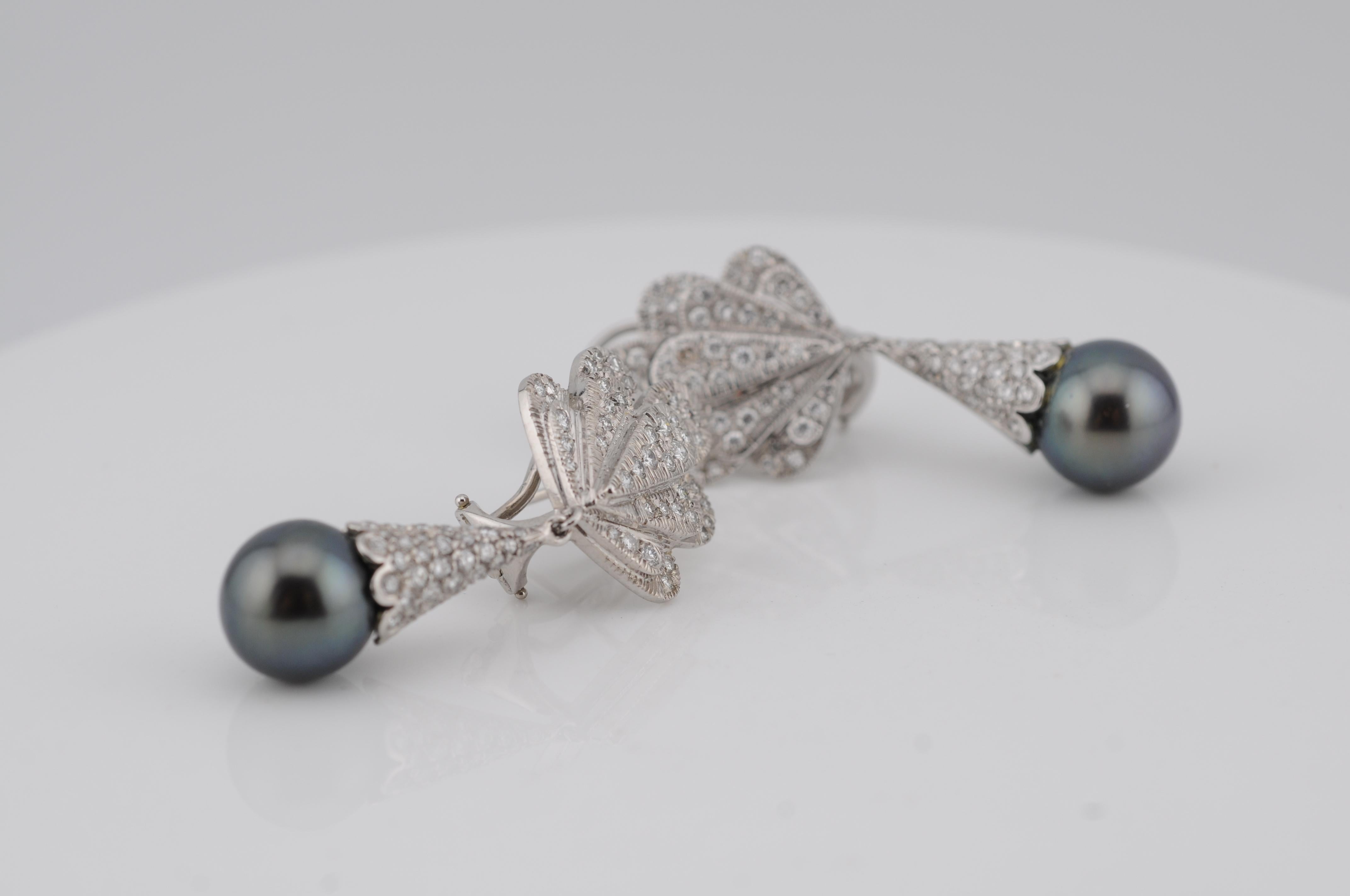 Eleganti orecchini realizzati in oro bianco 18 carati, ciascuno con perle di Tahiti di 11,3 mm di diametro. Il design a grappolo è interamente incastonato di diamanti scintillanti, che aggiungono brillantezza e raffinatezza alla bellezza naturale