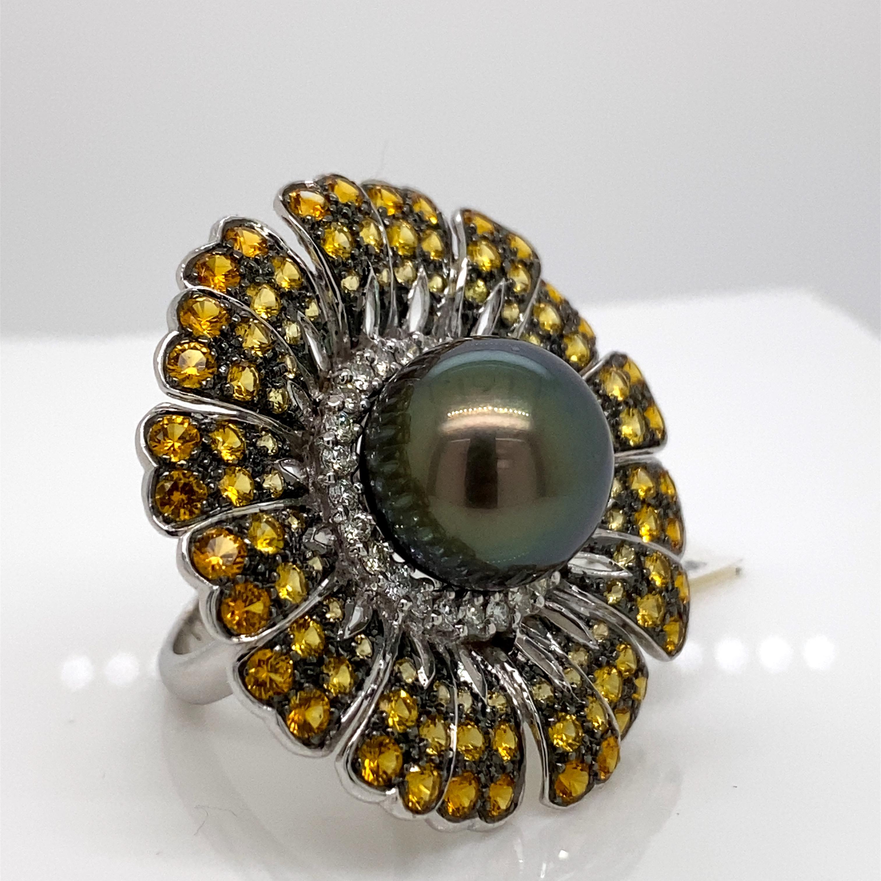 Exquisite and unique multi gemstone floral ring. 
Center Tahitian pearl surrounded by 4.80ct of round yellow sapphires heat and 0.78ct of round brilliant diamonds. 5.58ct total gemstone weight set in 18-karat white gold with black