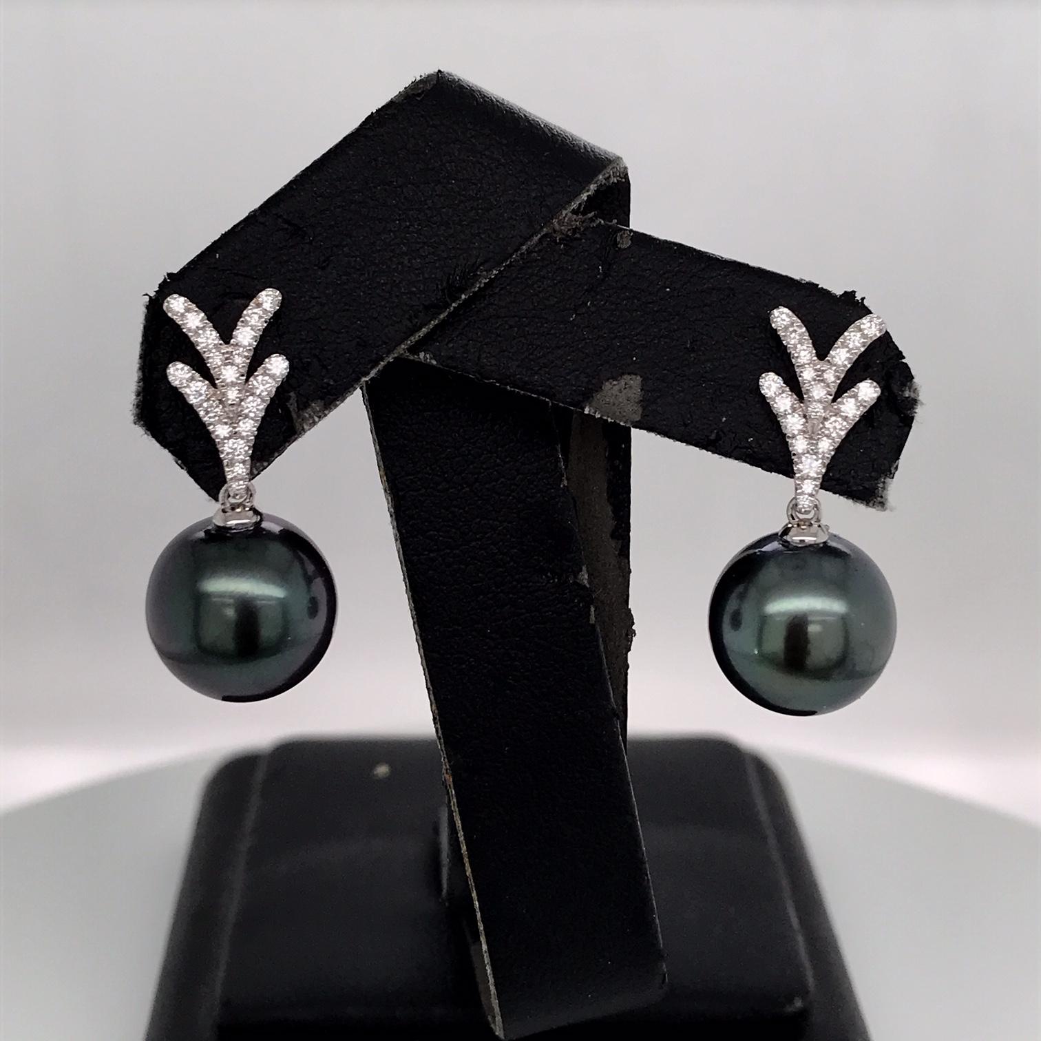 18K White gold drop earrings featuring two Tahitian pearls measuring 11-12 mm with 44 round brilliants weighing 0.26 carats. 
Color G-H
Clarity SI