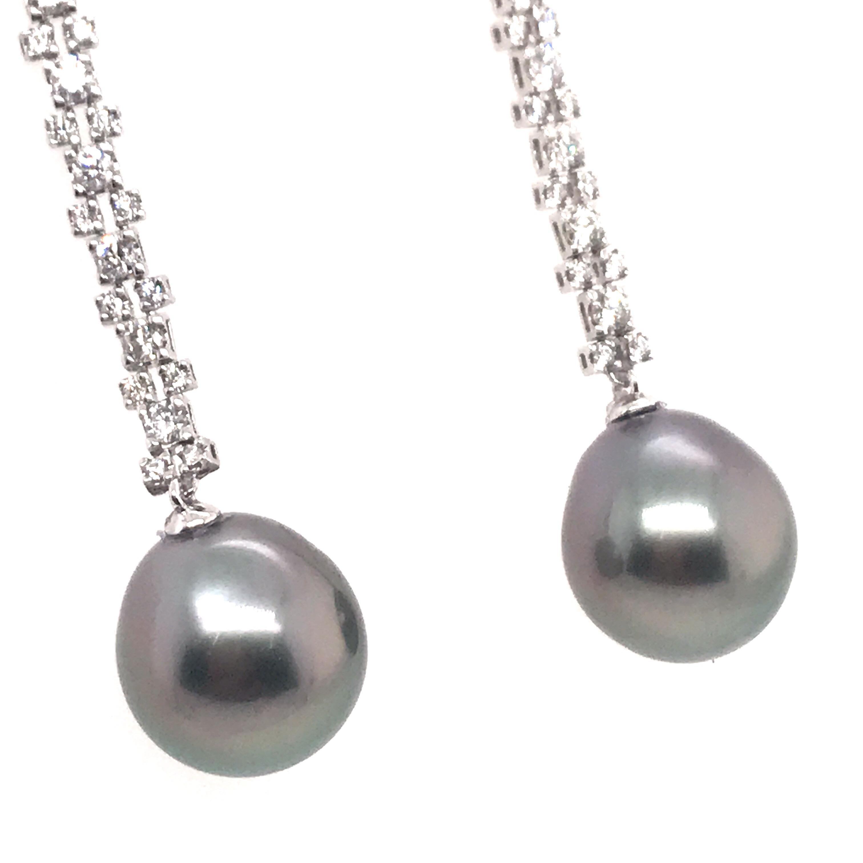 18k White gold drop earrings featuring two Tahitian pearls measuring 12-13 mm and 64 round brilliants weighing 1.08 carats. 
Color G-H
Clarity SI