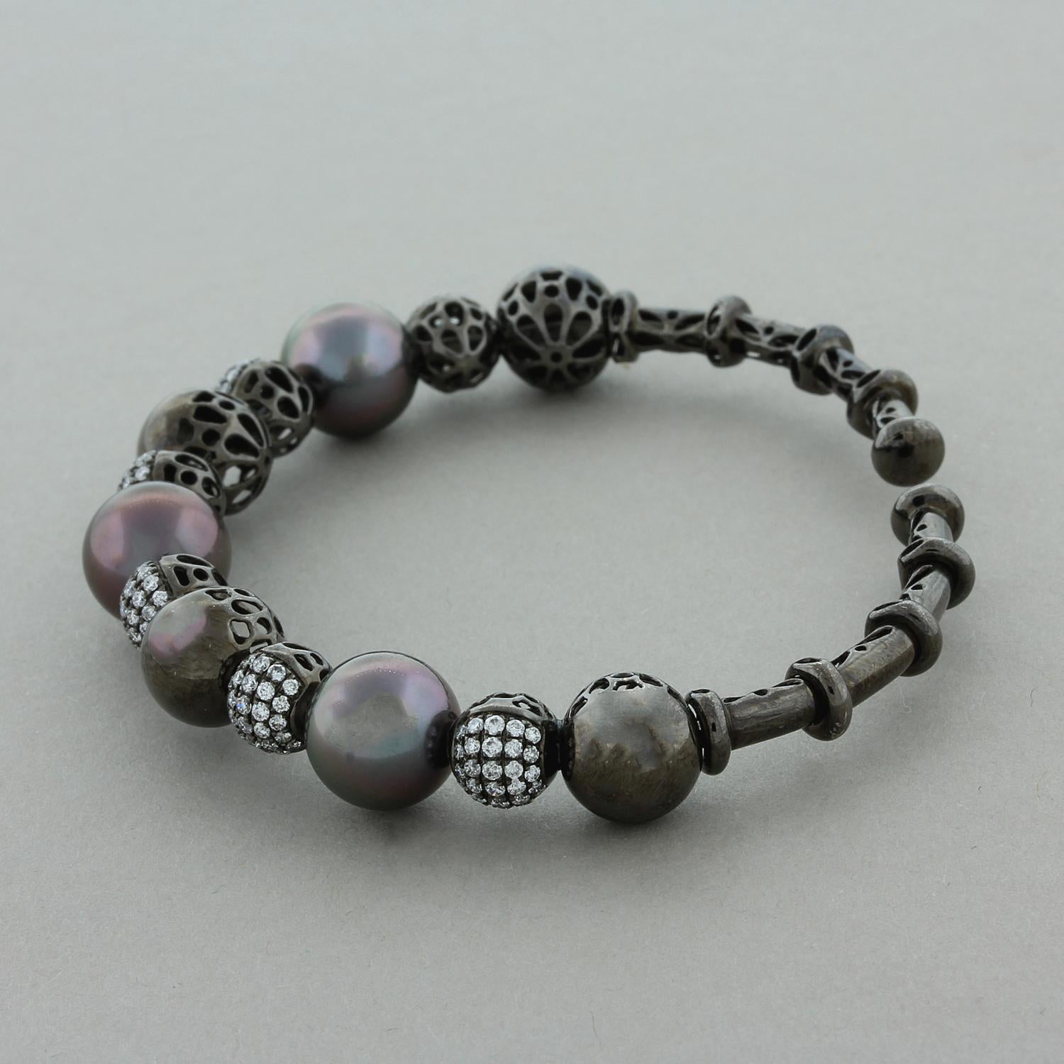 Una magnífica pulsera brazalete con 3 perlas de Tahití redondas y de bellos colores. Los acentúan 1,32 quilates de diamantes redondos de talla brillante de calidad VS engastados en oro de 18 quilates rodiado para dar a la pulsera un elegante acabado