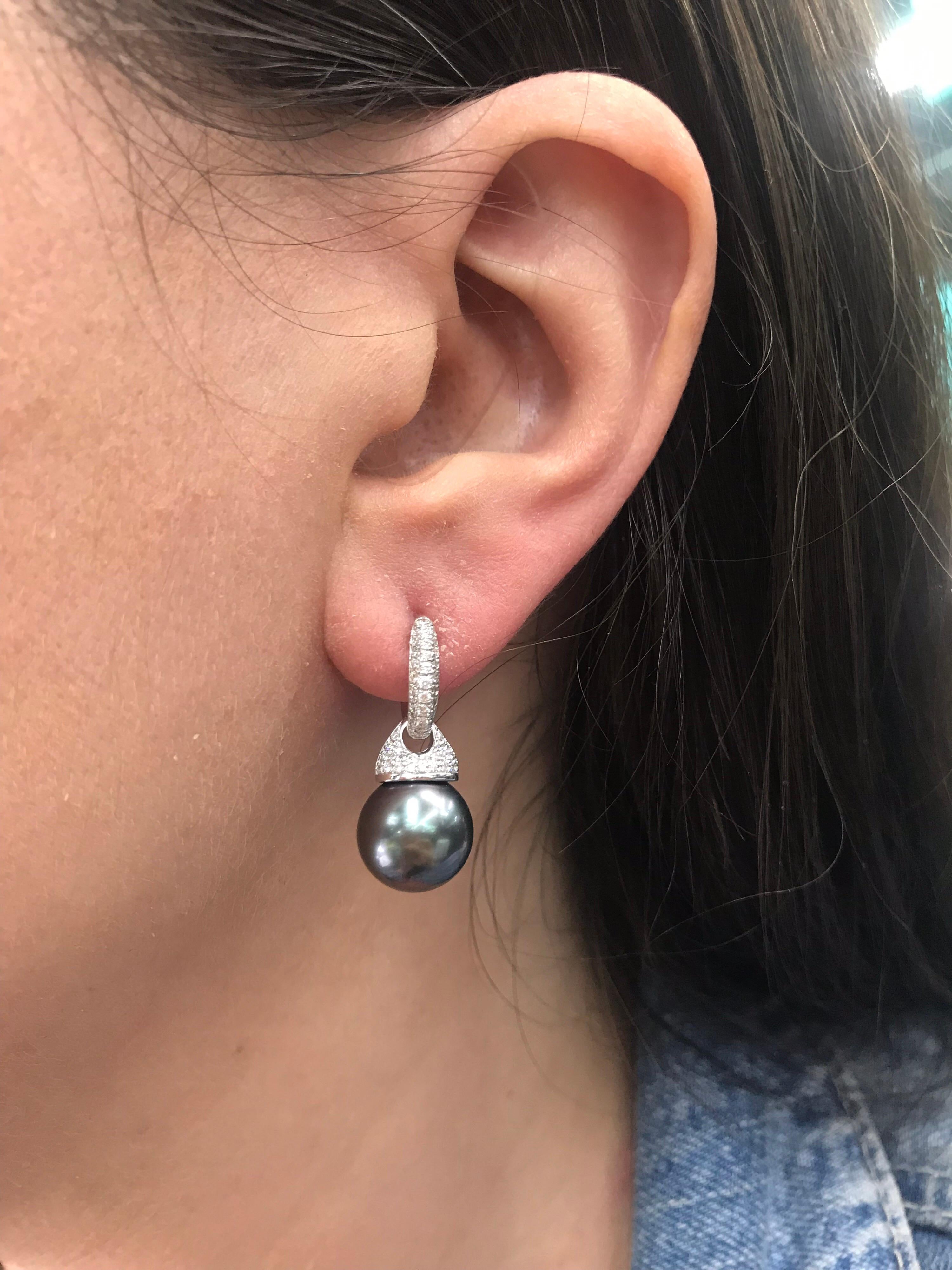 14K White gold drop earrings featuring two Tahitian Pearls measuring 10-11 mm flanked with round brilliants weighing 0.44 carats. 
Can be worn as a huggie earring