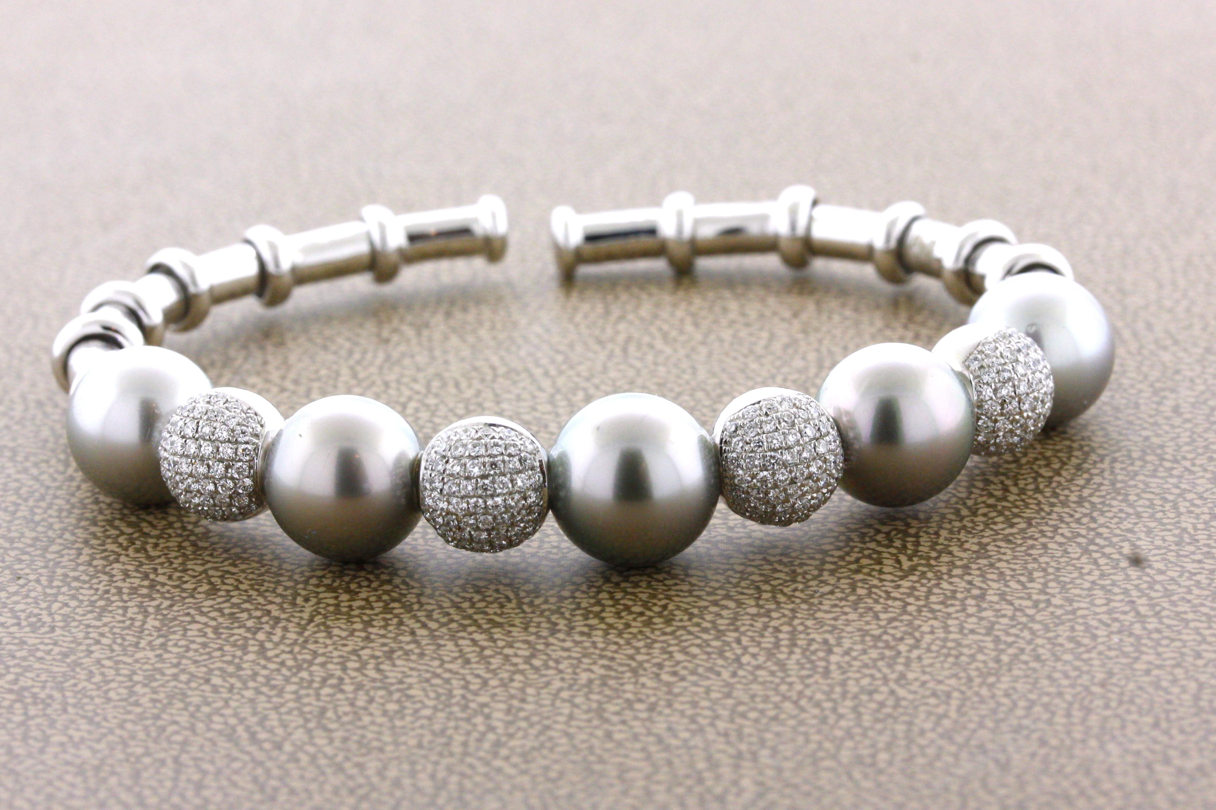 A beautiful and chic bangle featuring 5 high quality matching Tahitian pearls. They measure 10 – 11 millimeters each, are blemish free, and have a rich silver-Tahitian color. Between each pearl is a diamond studded gold sphere which adds brightness