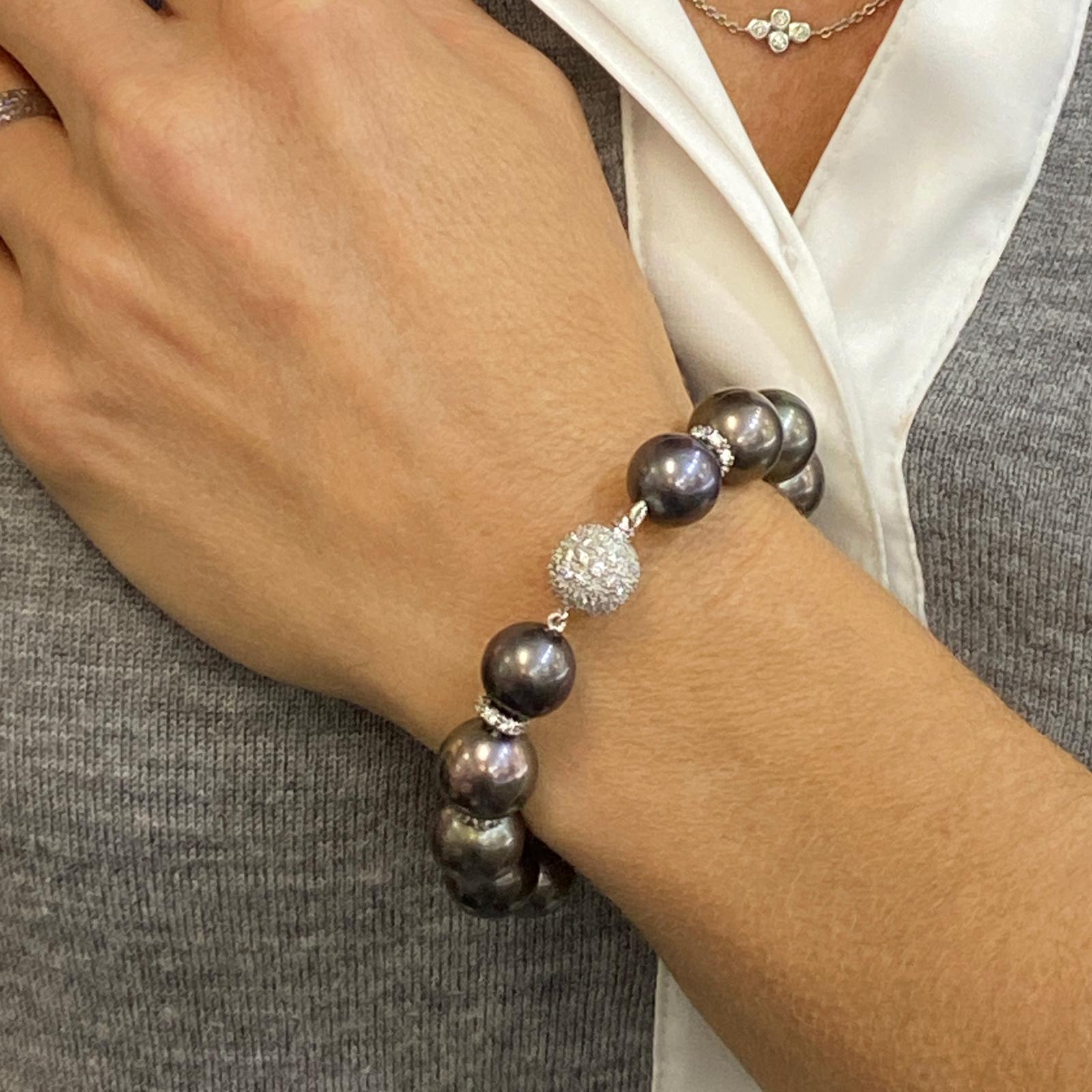 Tahitian pearl and diamond bracelet fashioned in platinum. The bracelet features 12-12.5 mm beautifully matched Tahitian pearls with diamond rhondels and diamonds clasp. The diamonds weigh approximately 3.88 carat total weight. The bracelet measures