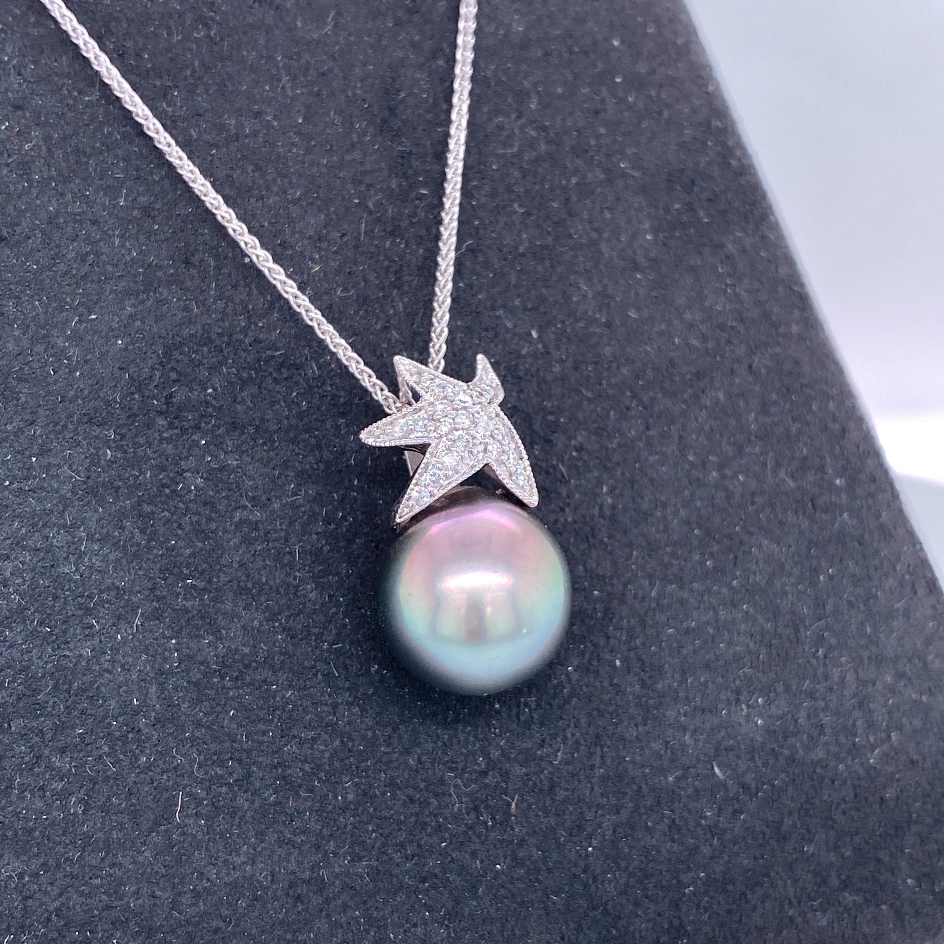 18K White gold pendant necklace featuring one diamond starfish motif weighing 0.13 carats and a Tahitian pearl measuring 11-12 mm.
Color G-H
Clarity SI