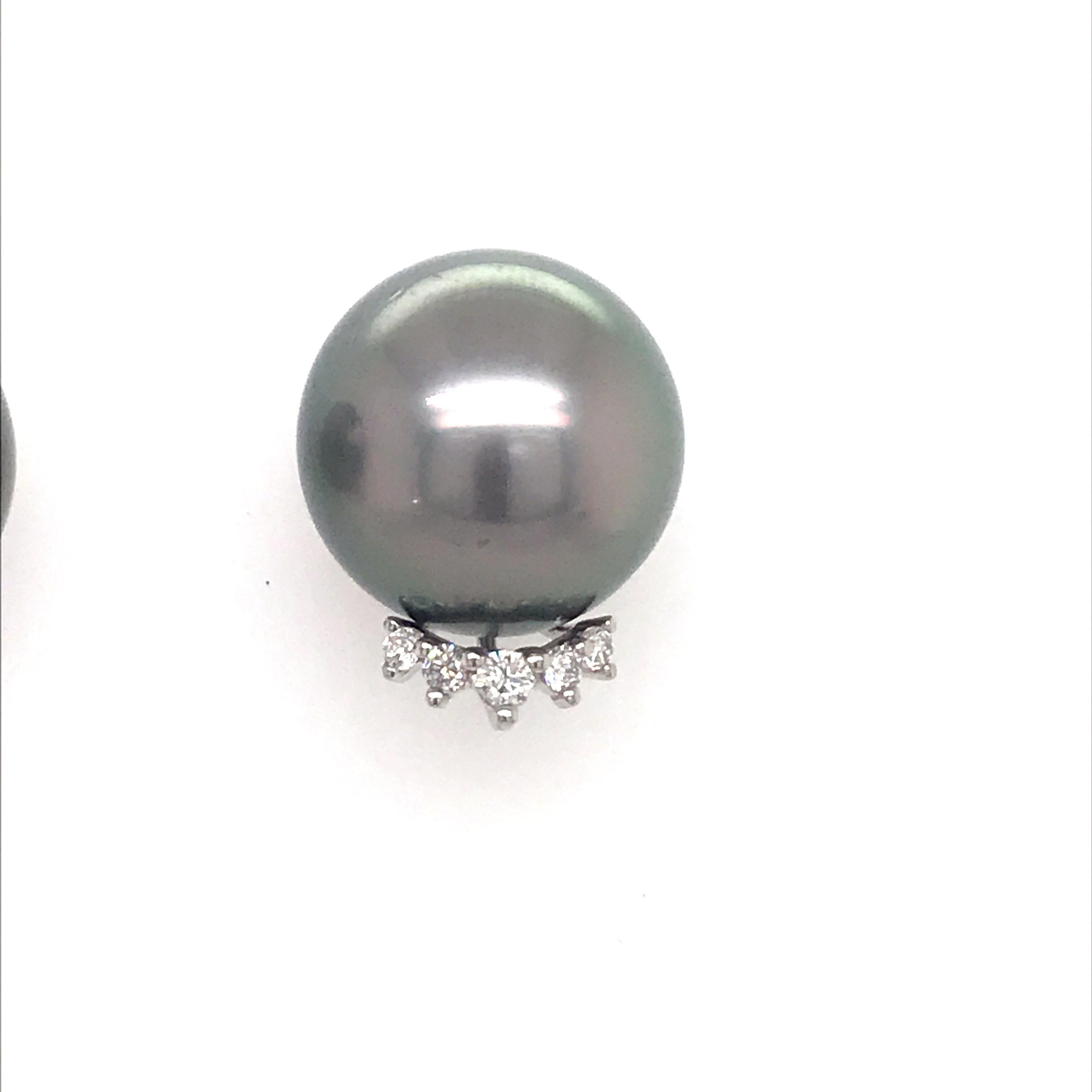 18K White gold stud earrings featuring two grey Tahitian pearls measuring 14-15 mm flanked with 10 round brilliants weighing 0.24 carats.
Color G-H
Clarity SI