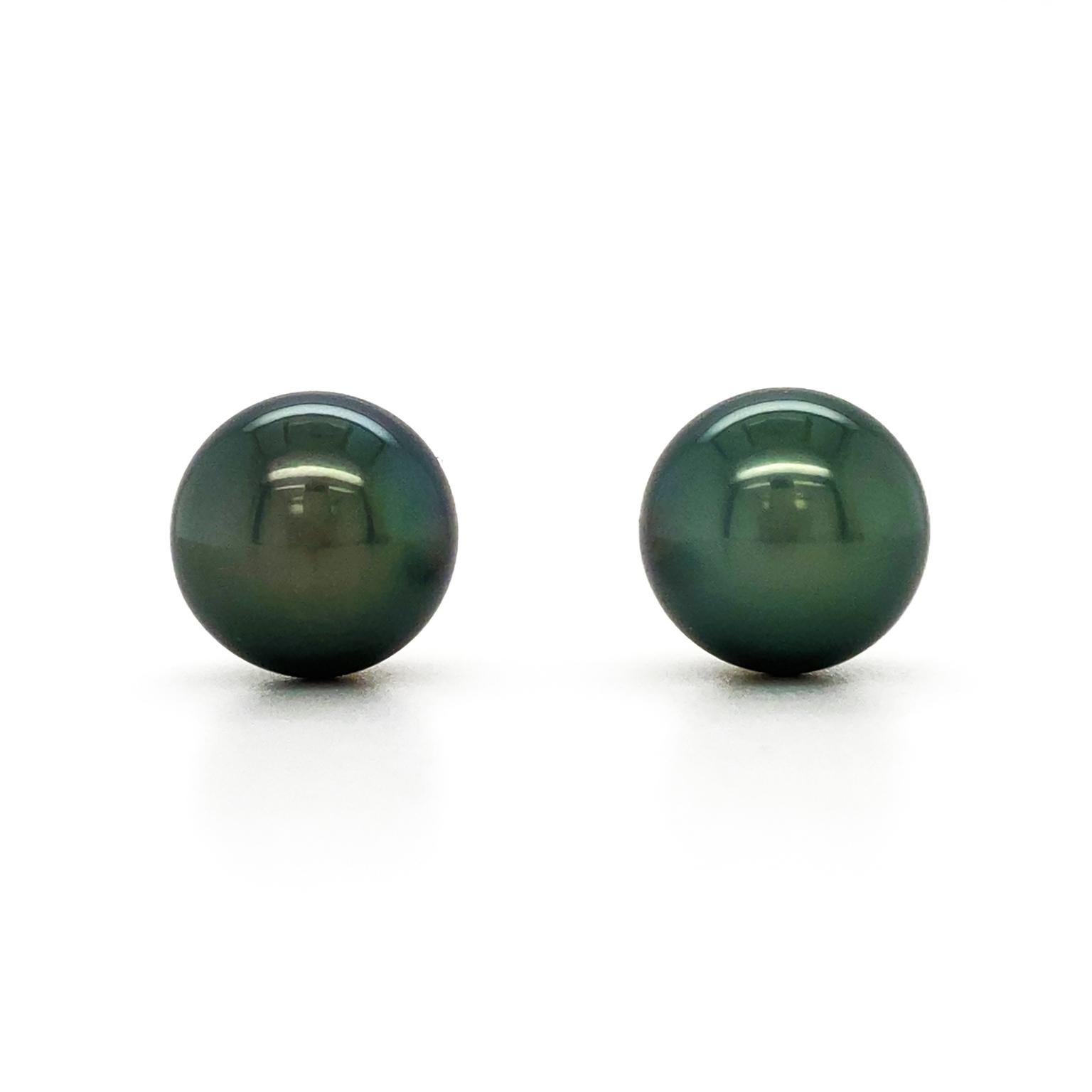 The luster of a Tahitian pearl is the focus of a unique interpretation of the classic pearl stud earrings. Deep forest green tones with an undercurrent of warm gold are visible as the light reflects across the gemstone. The total weight of the