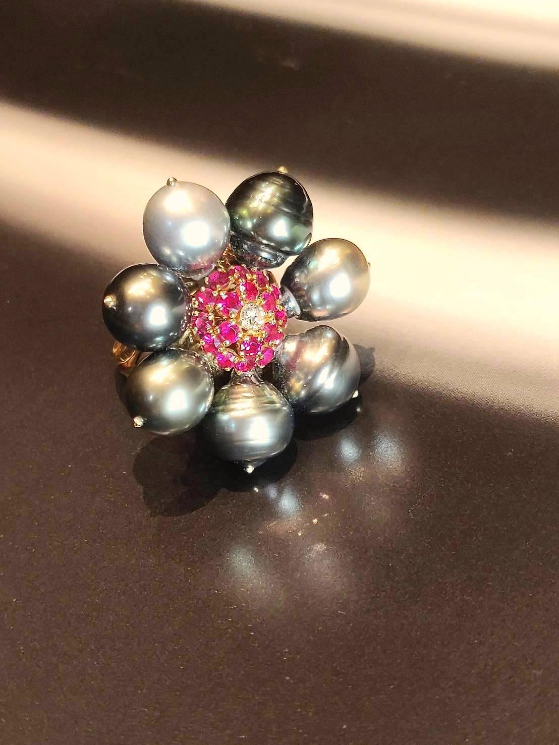 Flower Clustered Tahitian Pearl Ring in 18K Yellow Gold with Rubies and Diamonds. 

Gold: 18K Yellow Gold, 12.91 g
Tahitian Pearls: 7 pieces
Rubies: 1.26 ct
Diamond: 0.1 ct

Ring size: 57.5

Please let us know should you wish to have the ring