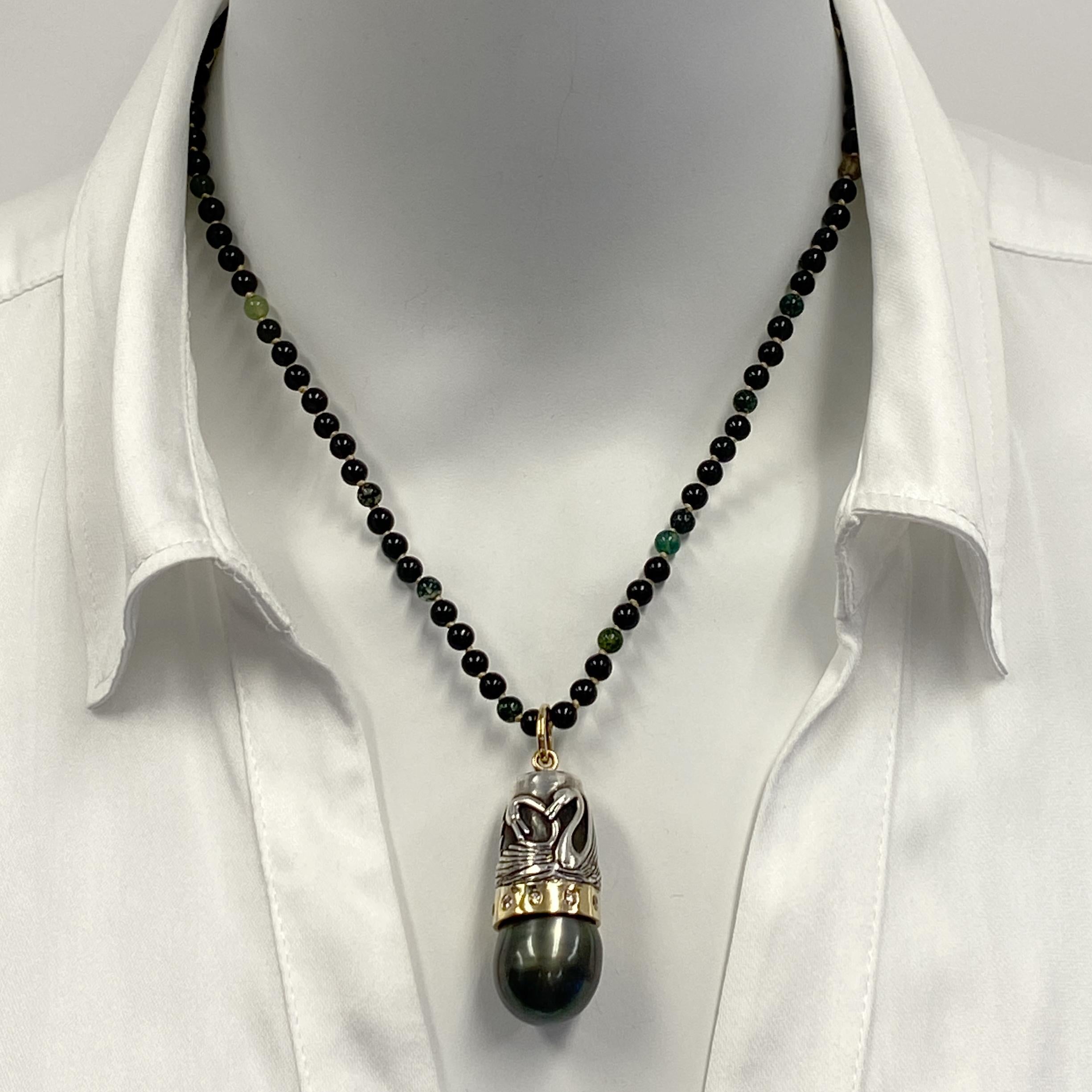 This one-of-a-kind pendant by Eytan Brandes features a huge Tahitian black pearl set in an 18 karat yellow gold bezel burnished with pale brown diamonds.  Topping the bezel is a vintage sterling silver thimble featuring two pairs of loving swans