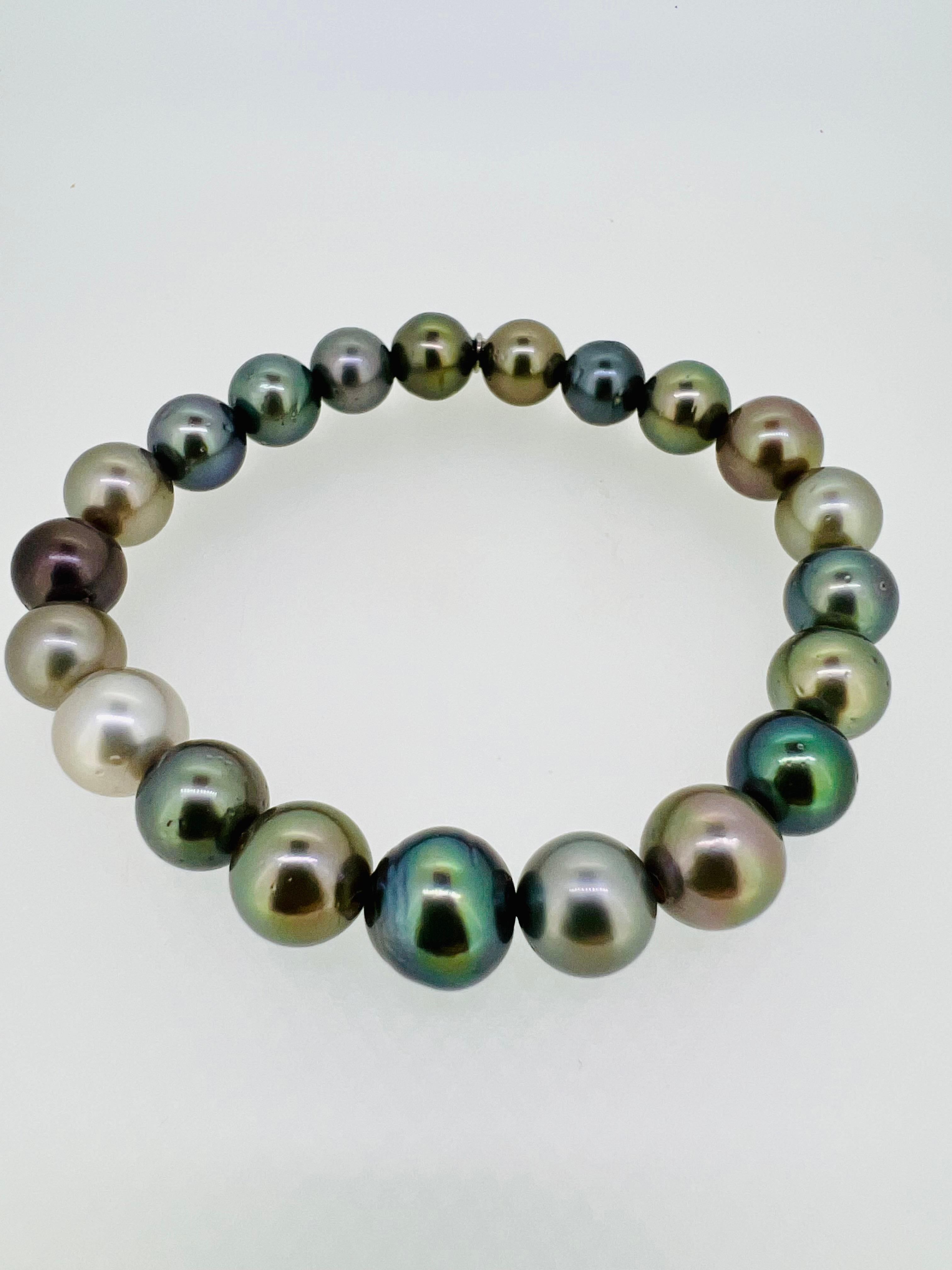 Introducing a striking men's bracelet composed entirely of exquisite Tahitian pearls in varying sizes (9-11mm) and captivating shades of gray. Each pearl, renowned for its natural beauty and luster, carries the essence of the ocean and is treasured