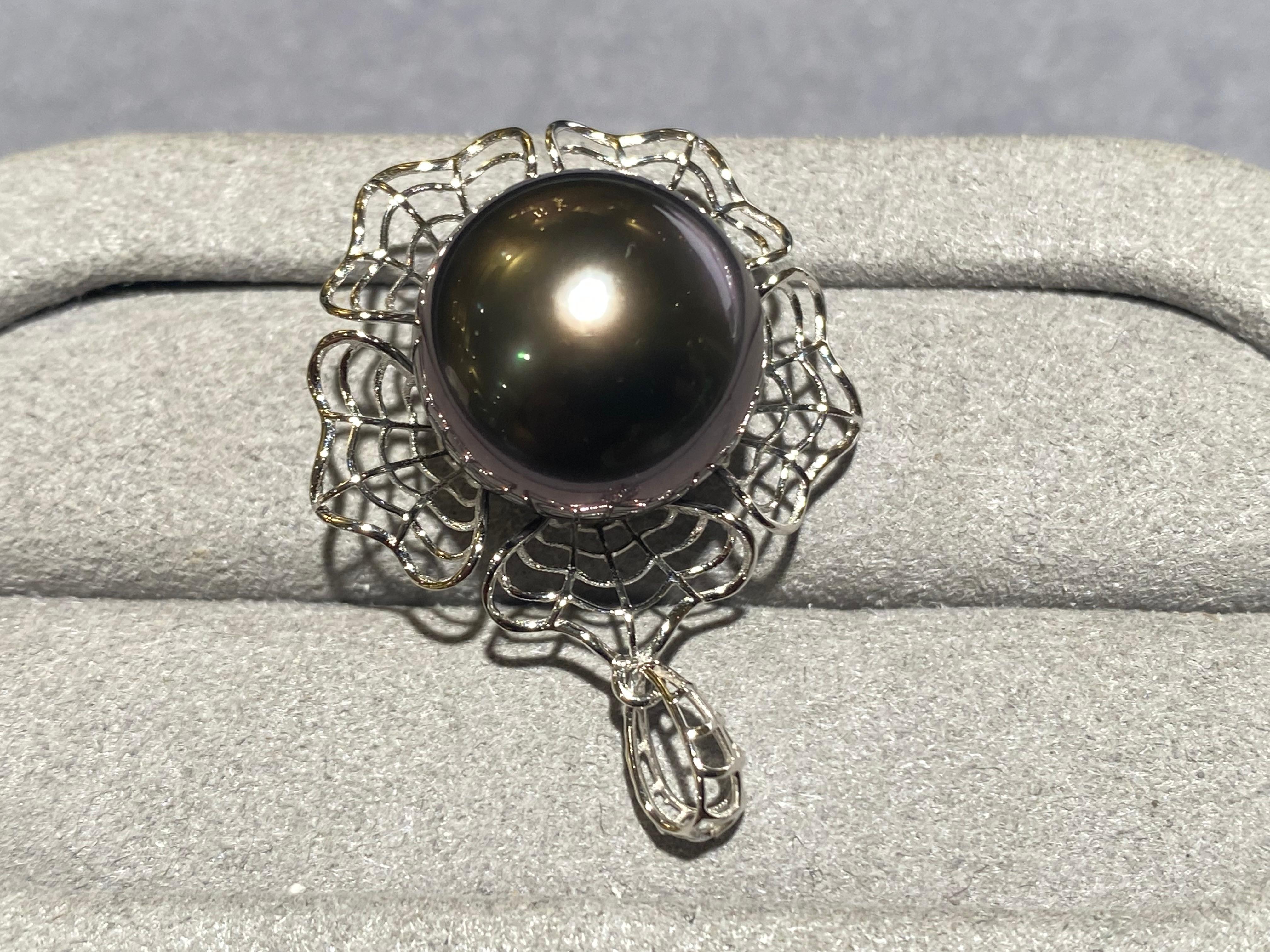 A 13.9 mm button tahitian pearl pendant in 18k white gold. This pendant is a flower design with the pearl set in the middle of the pendant. The pendant is in a mesh form and the bale matches this form as well. It is a very simple and fun design and