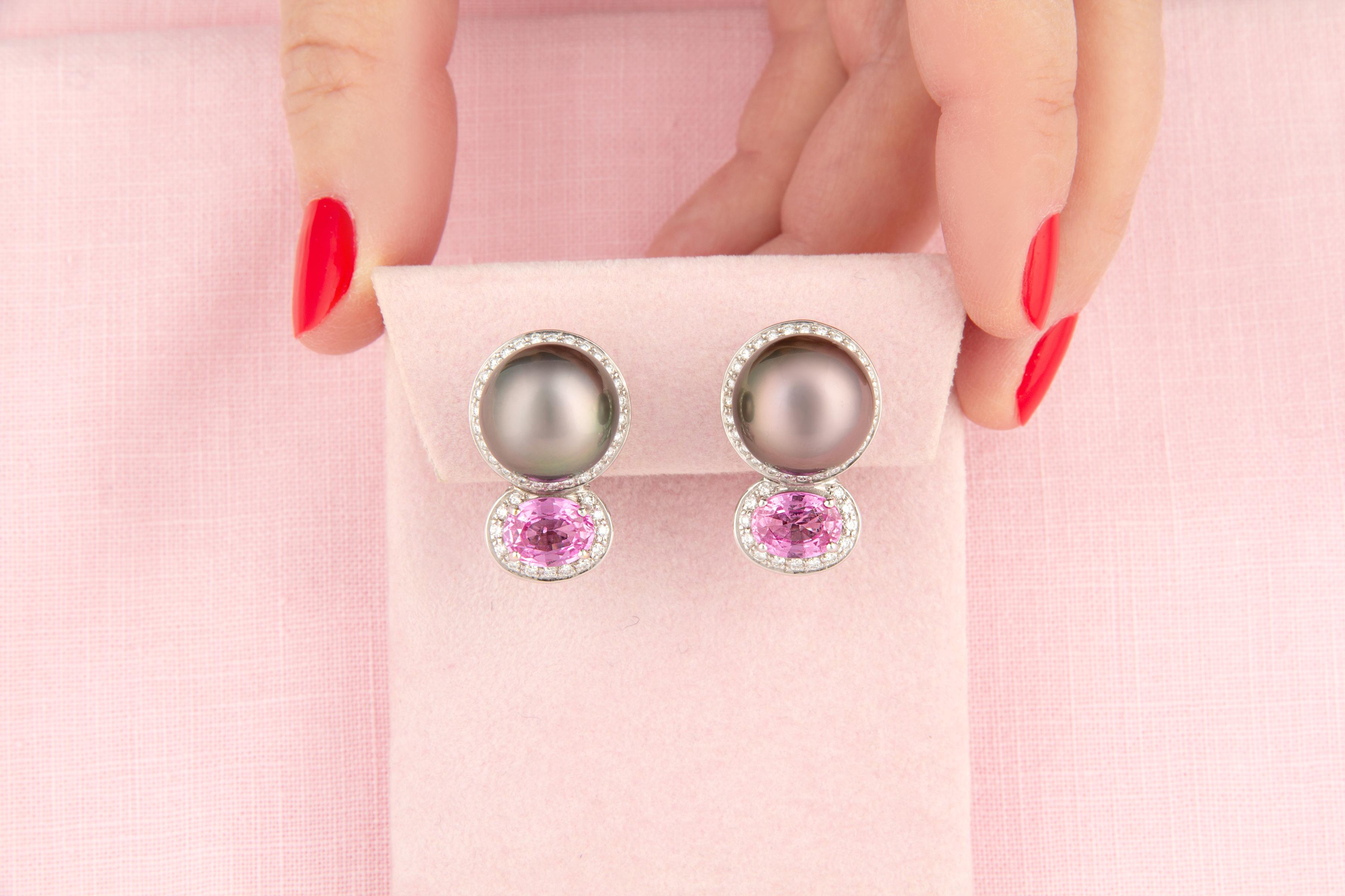 Este par de pendientes de perlas de Tahití presenta 2 espléndidas perlas de 13,5 mm de diámetro y tonos rosáceos. El diseño se completa con 2 zafiros rosas facetados de talla ovalada y color brillante para un peso total de 4,98 quilates. El conjunto