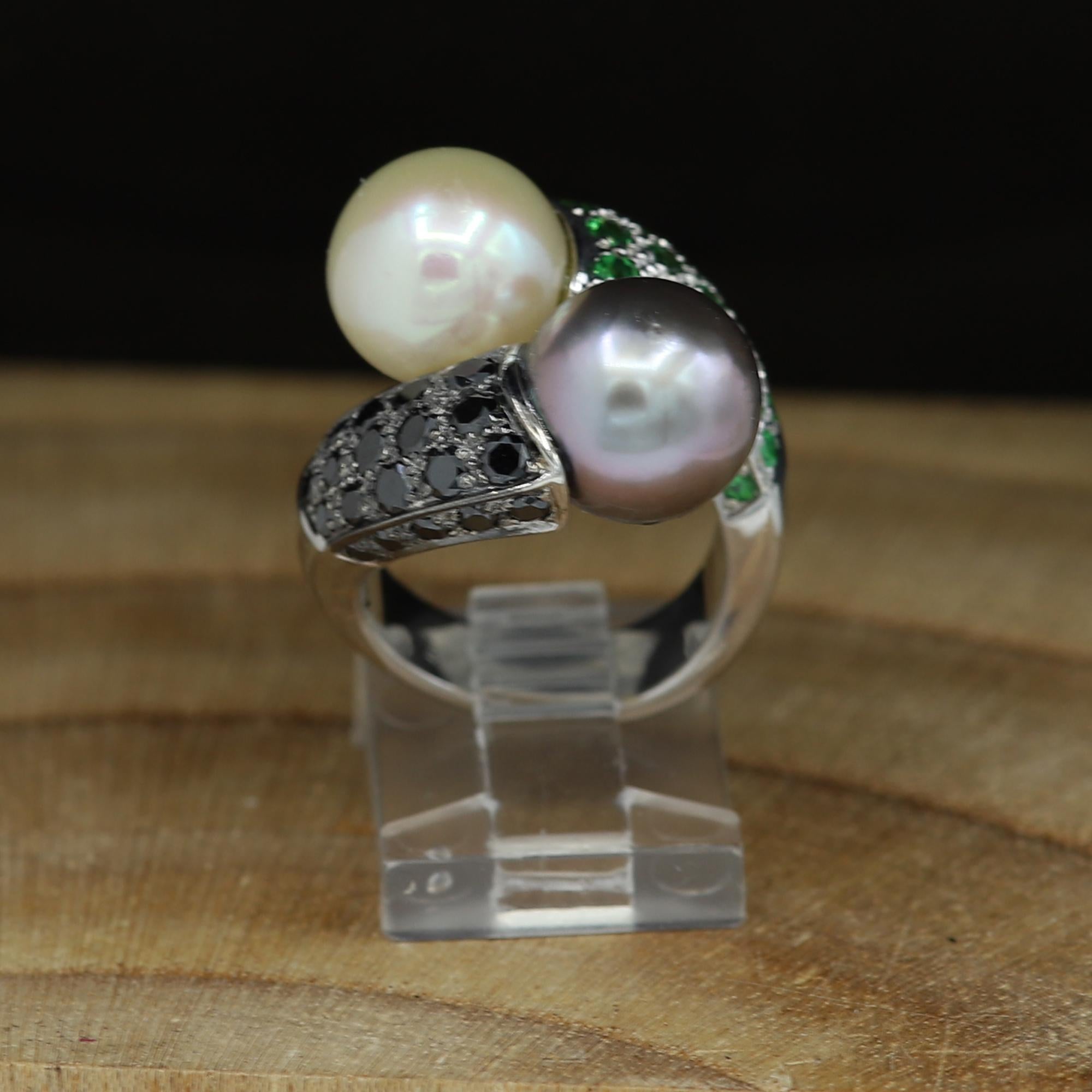 Unique double pearl Ring 18k White Gold, with Tsavorite and Black Diamonds, in the center are two Pearls, one is a Tahitian Grey Pearl, and the other is South Sea light yellowish - beige tone - both are approx 11mm in size.
Finger size  5.5 - cannot