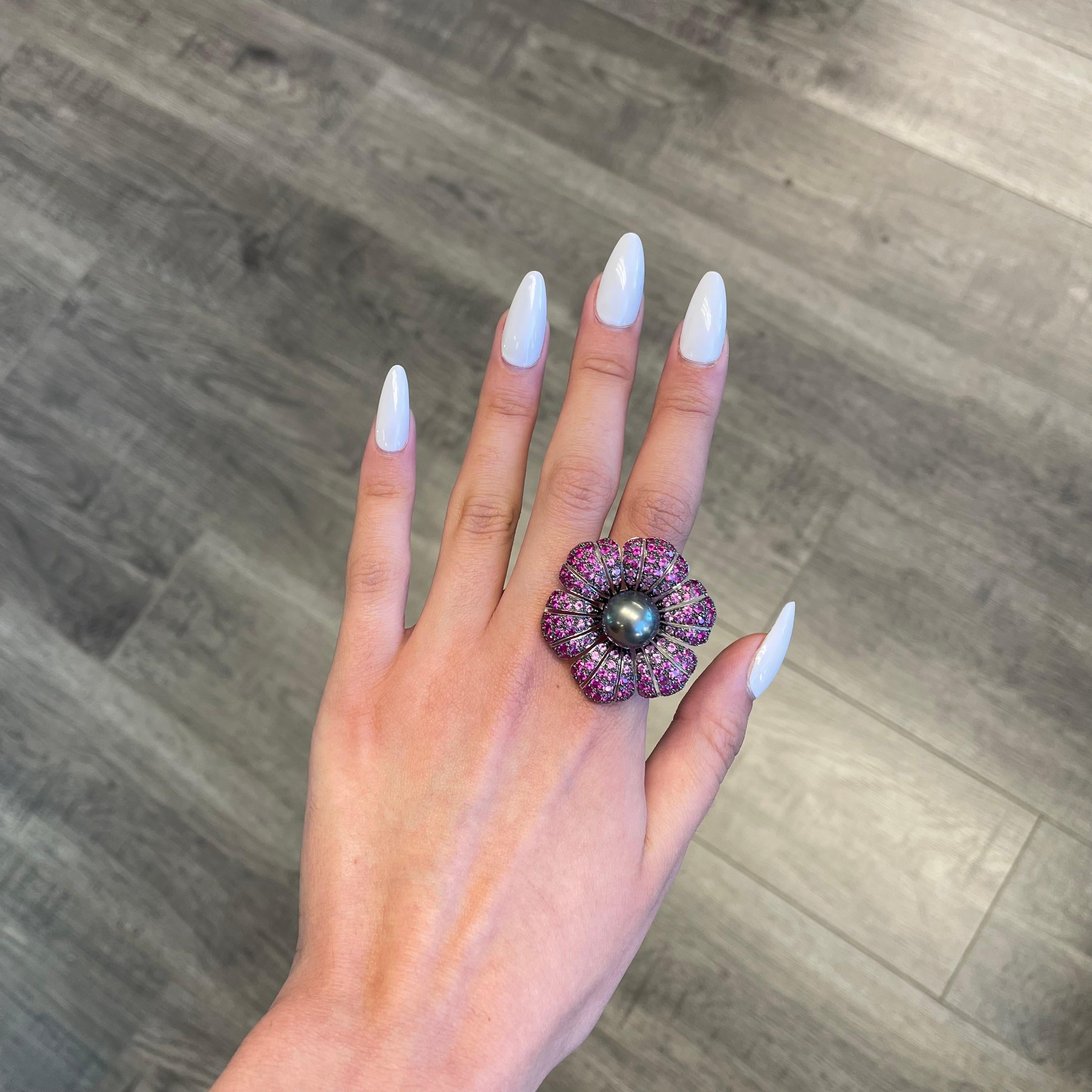 Exquisite and unique multi gemstone floral ring. 
Center Tahitian pearl surrounded by 8.38ct of rubies and pink sapphires heat, set in 18-karat white gold with black rhodium. 
Accommodated with an up to date appraisal by a GIA G.G. upon request.