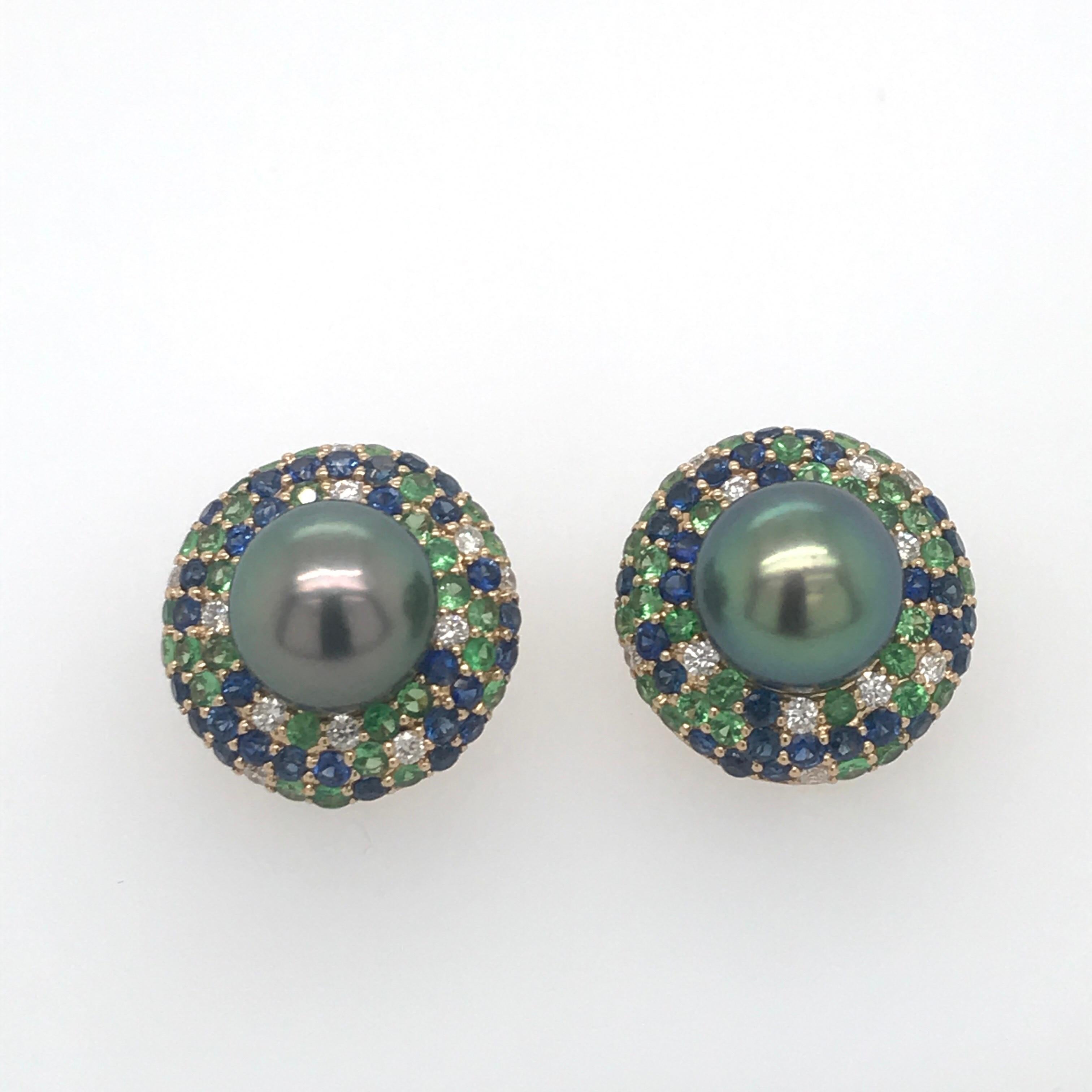 18K Yellow Gold earrings featuring two Tahitian pearls measuring 10-11 mm flanked with diamonds, 0.42 carats, blue sapphires, 1.95 carats and green tsavorite, 1.50 carats. 