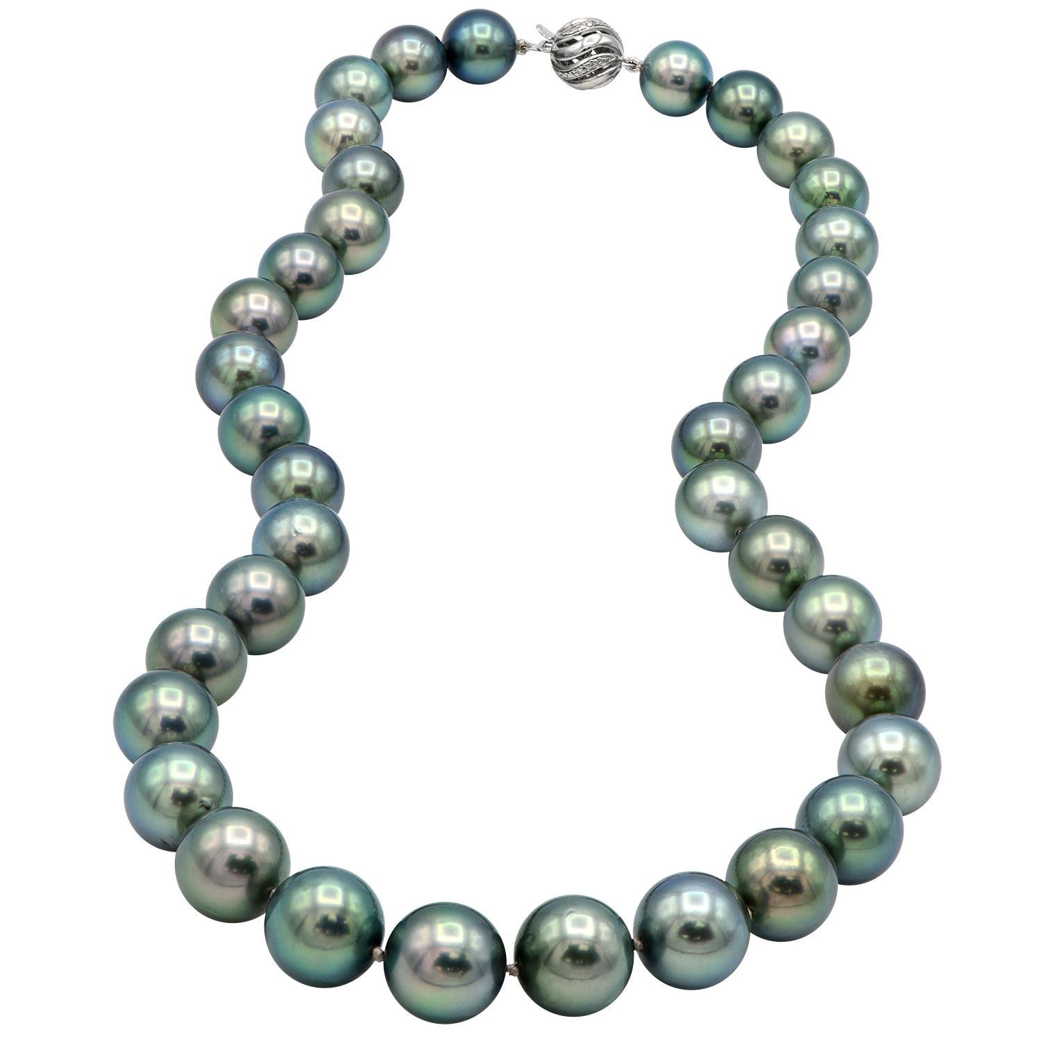 This stunning Tahitian pearl strand is made from 10-12.7mm round grey/black pearls with gorgeous undertones. There are 37 pearls that are expertly strung with a double knot between each pearl to make an 18 inch strand. The necklace closes with a 14