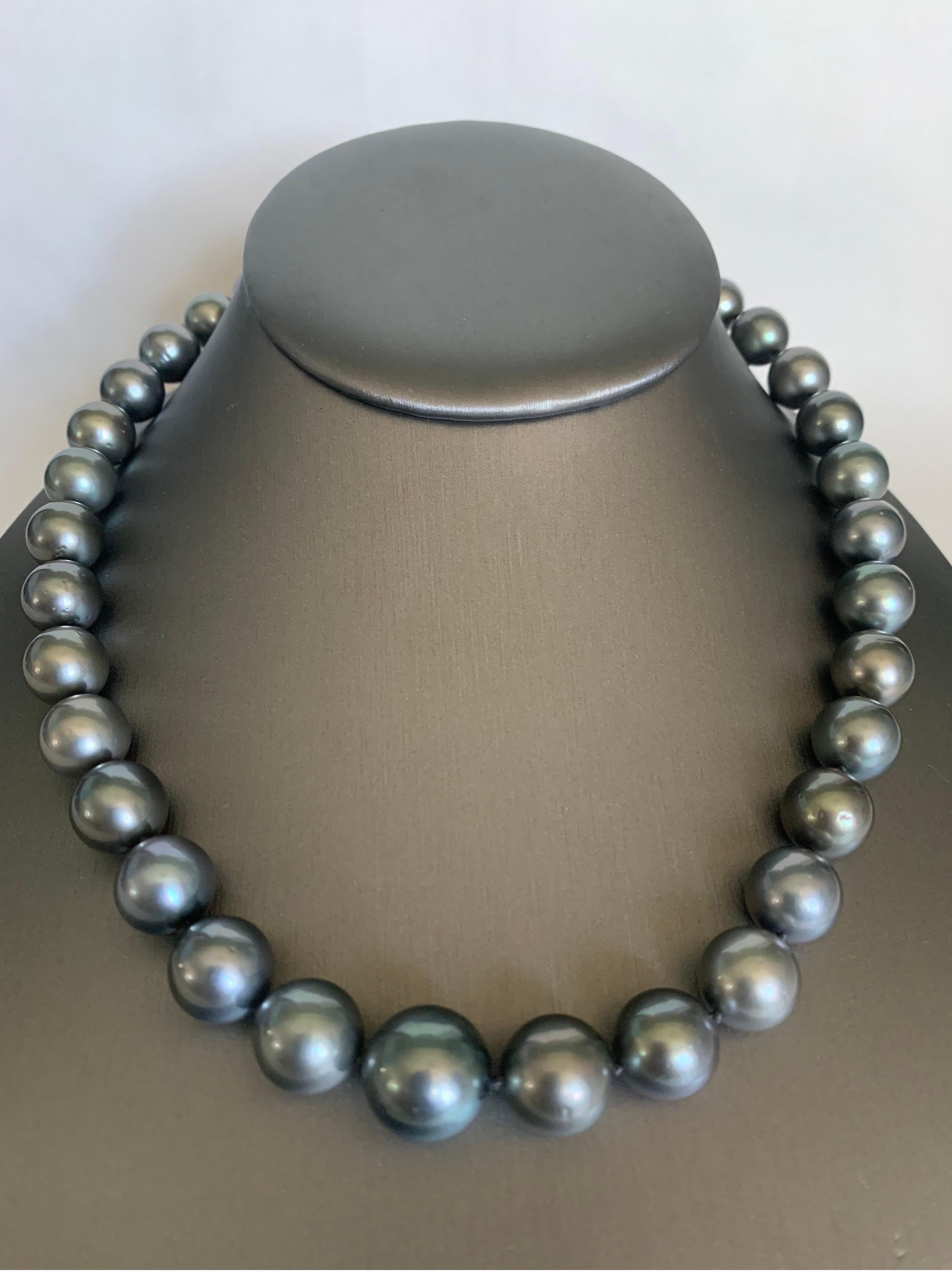 Werten Sie Ihren Look mit einer zeitlosen, abgestuften Perlenkette auf. Diese 17-18 Zoll lange Strangkette ist vollständig geknotet und von Hand mit passender Seidenkordel aufgefädelt. Das Collier besteht aus 35 glänzenden Tahiti-Perlen von 10-13,5