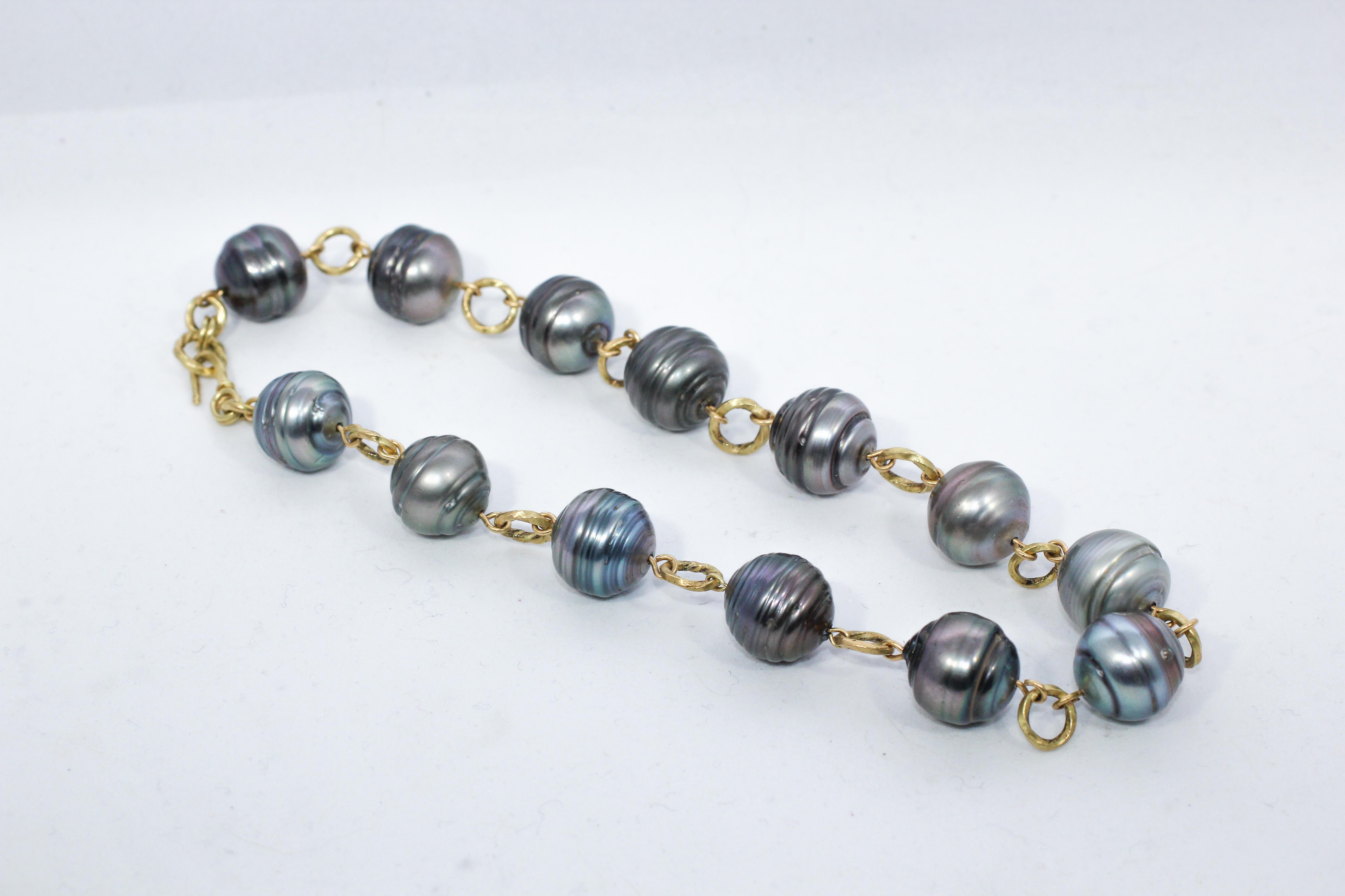 Midnight Pearl Necklace is a beautifully versatile beaded link necklace. Lustrous black and green large baroque pearls are wrapped in recycled 18k gold and separated by 18k gold links. The links are twisted to play up the concentric circles in these