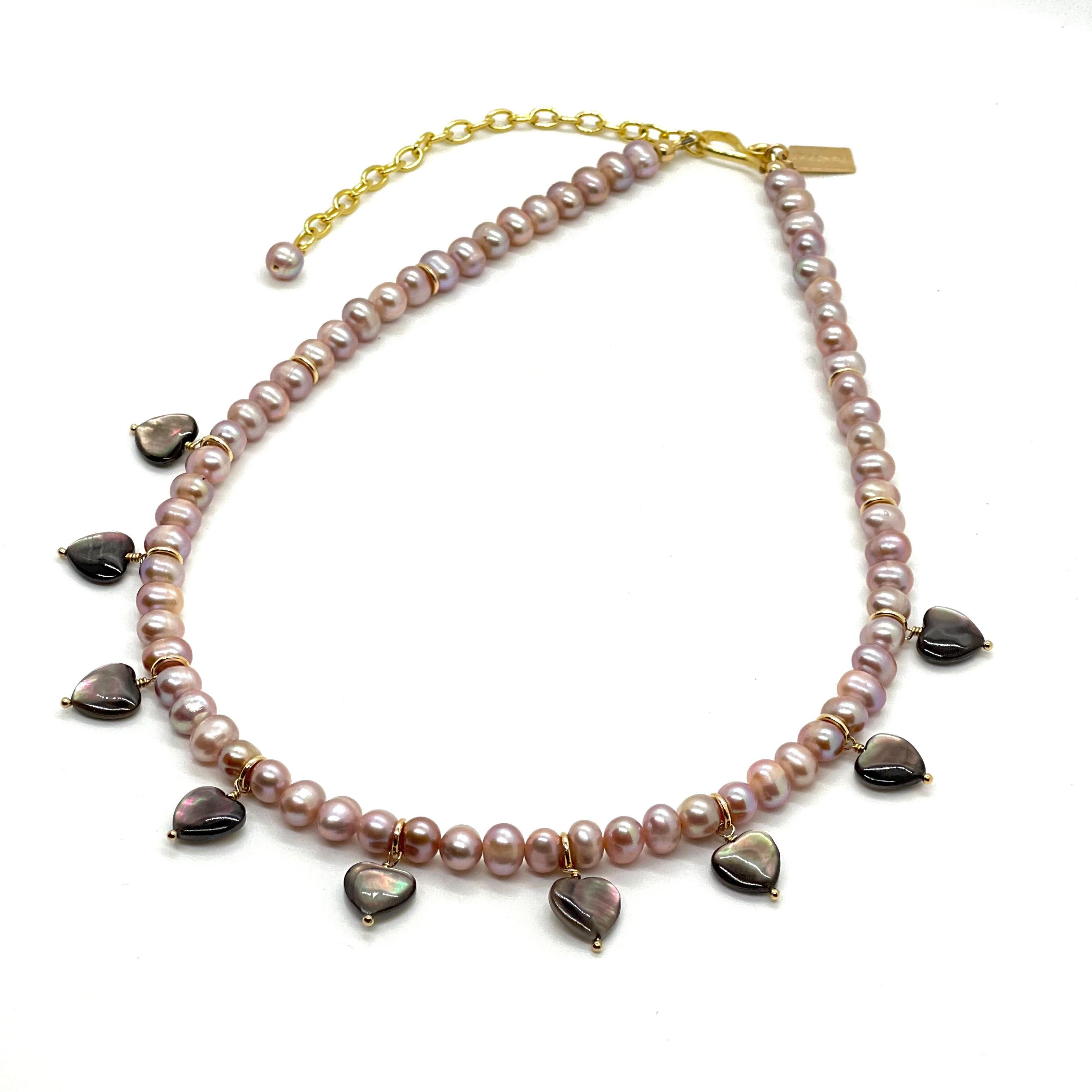 Dieses Collier besteht aus lavendelfarbenen ovalen Perlen mit handgefertigten Herzen aus schwarzen Tahiti-Muscheln. Die schwarzen Herzmuscheln aus Tahiti verleihen einen so schönen irisierenden Glanz, dass es sich anfühlt, als hätte man Regenbögen