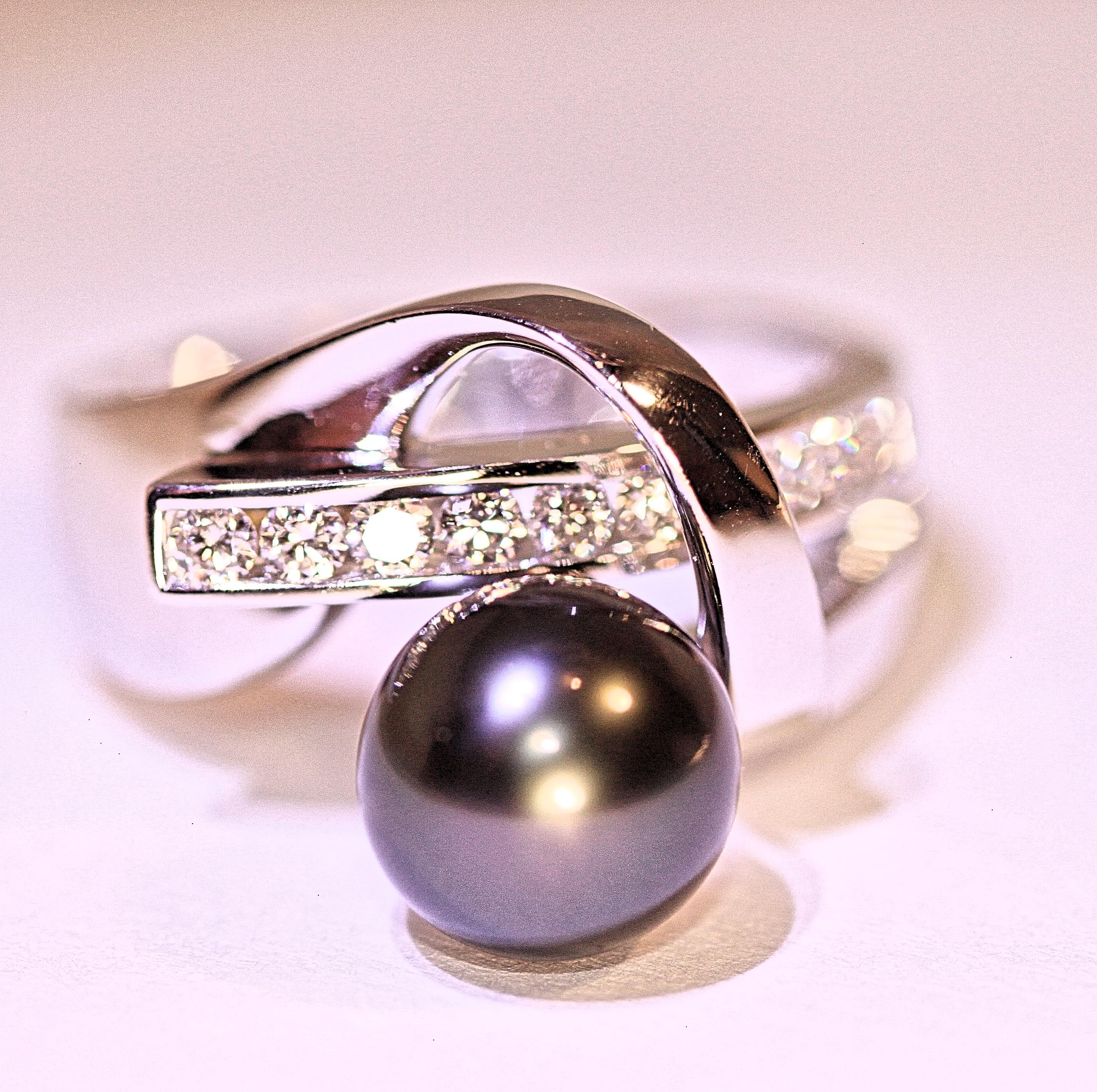 A delightful 14 karat white gold right hand ring with a beautiful black Tahitian pearl.  The pearl measures 8.3 mm and it is black with minor blemishes and good luster.  The ring has 10 round 
brilliant cut diamonds that weigh .33 carat total.  The