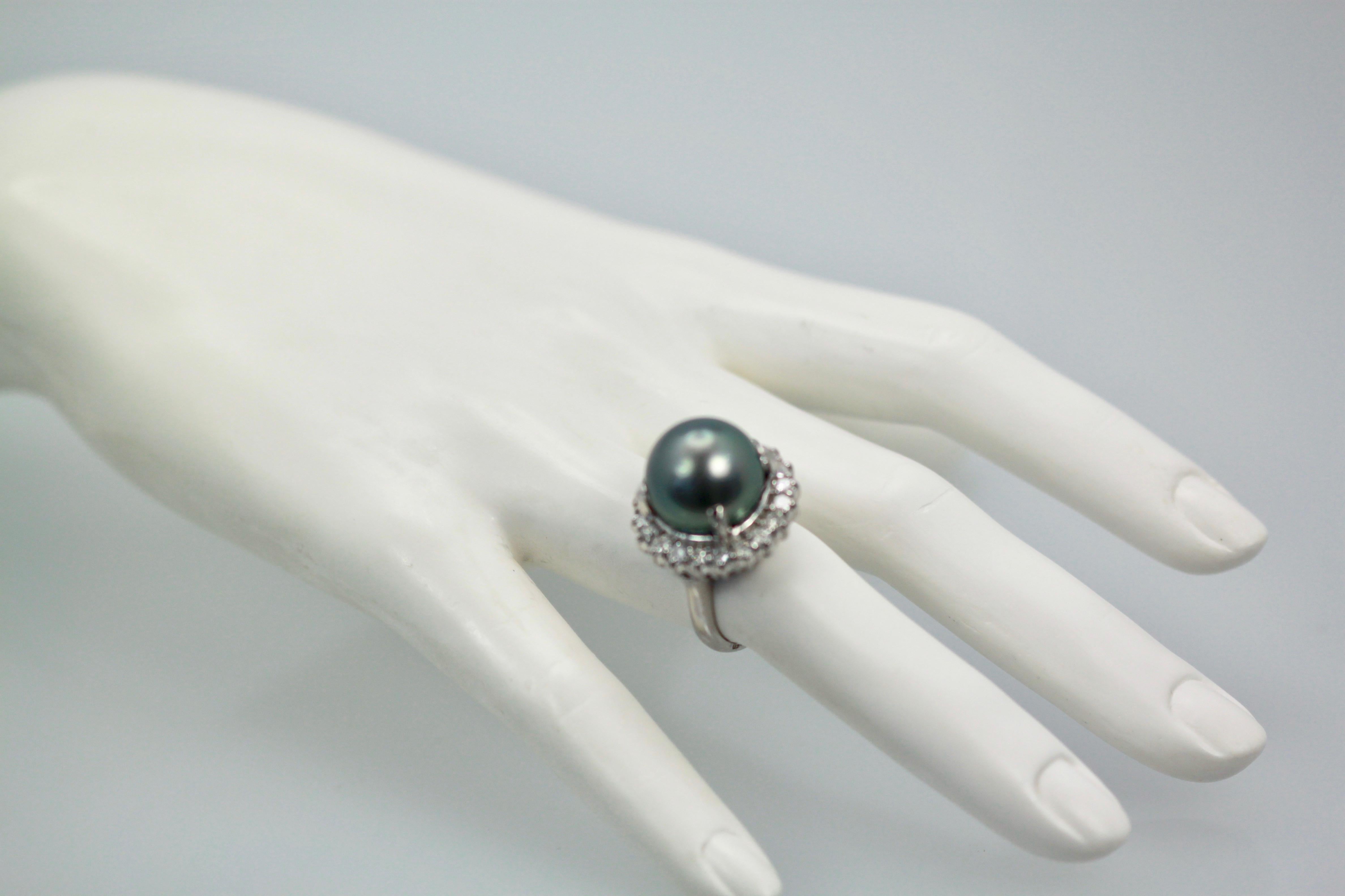 This Tahitian South Sea Black Pearl ring weighs 12.9 grams and the Pearl is 14.33 mm round.  The Diamond surround makes this ring 20.37 mm round.  There are 21 Diamonds totaling 1.05 Carats the Diamonds are G in color and VVS1 in clarity.  This ring