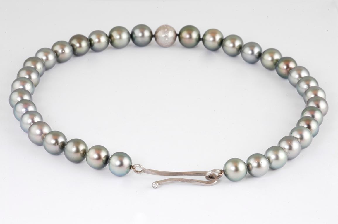 Tahitian Southsea grey pearls with handmade platinum hammered ball set with flush set brilliant cut diamonds, made in Notting Hill London by renowned British jewellery designer Malcolm Betts.

The distinguishing feature of these pearls is their