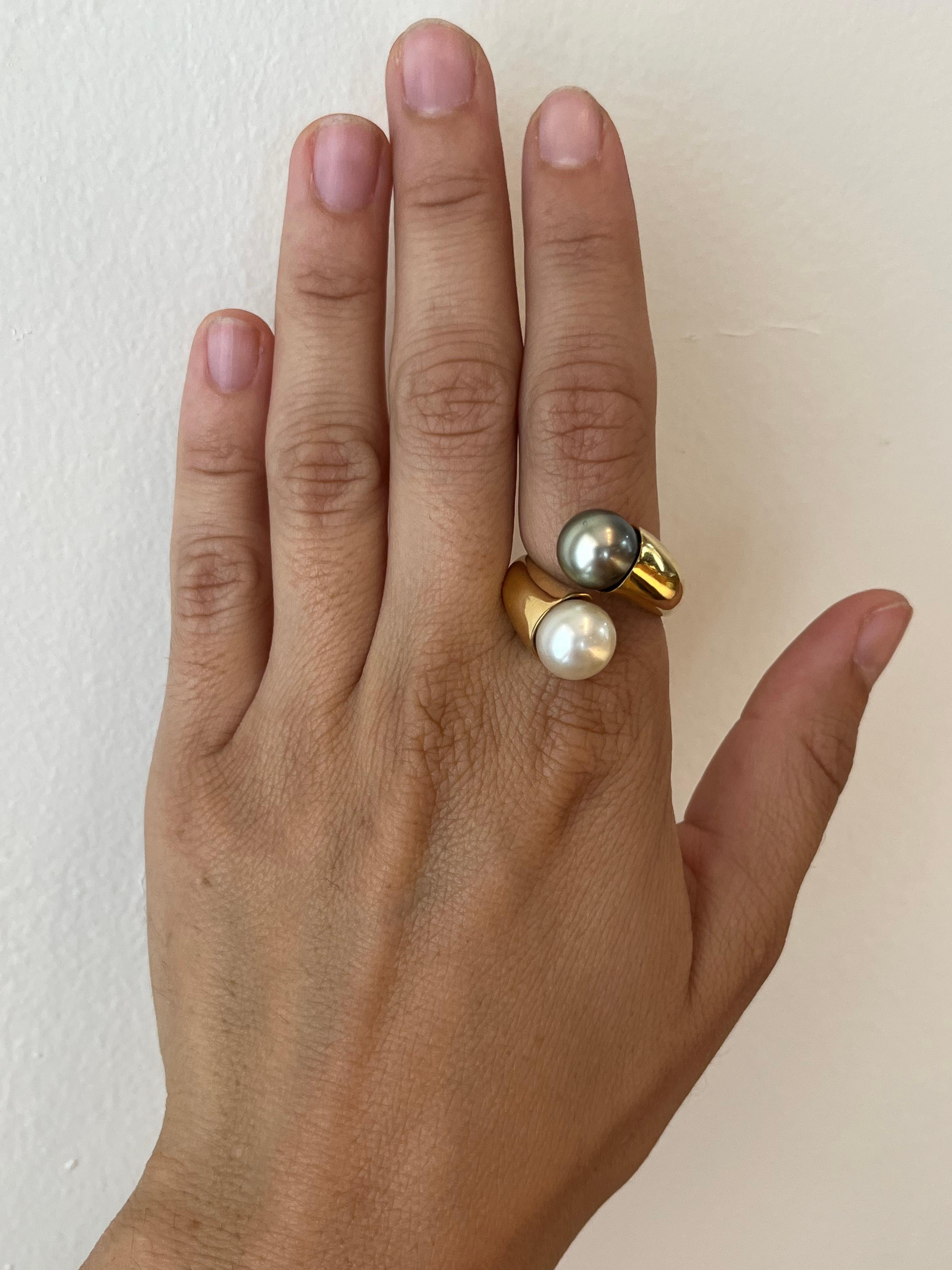 Cette bague croisée toi et moi en or jaune 18 carats est ornée de deux magnifiques perles de Tahiti, l'une blanche et l'autre noire, pour un contraste saisissant. Taille 8.

Provenant de la Collection Estate Jewelry Collection de Bracken Jewelers à