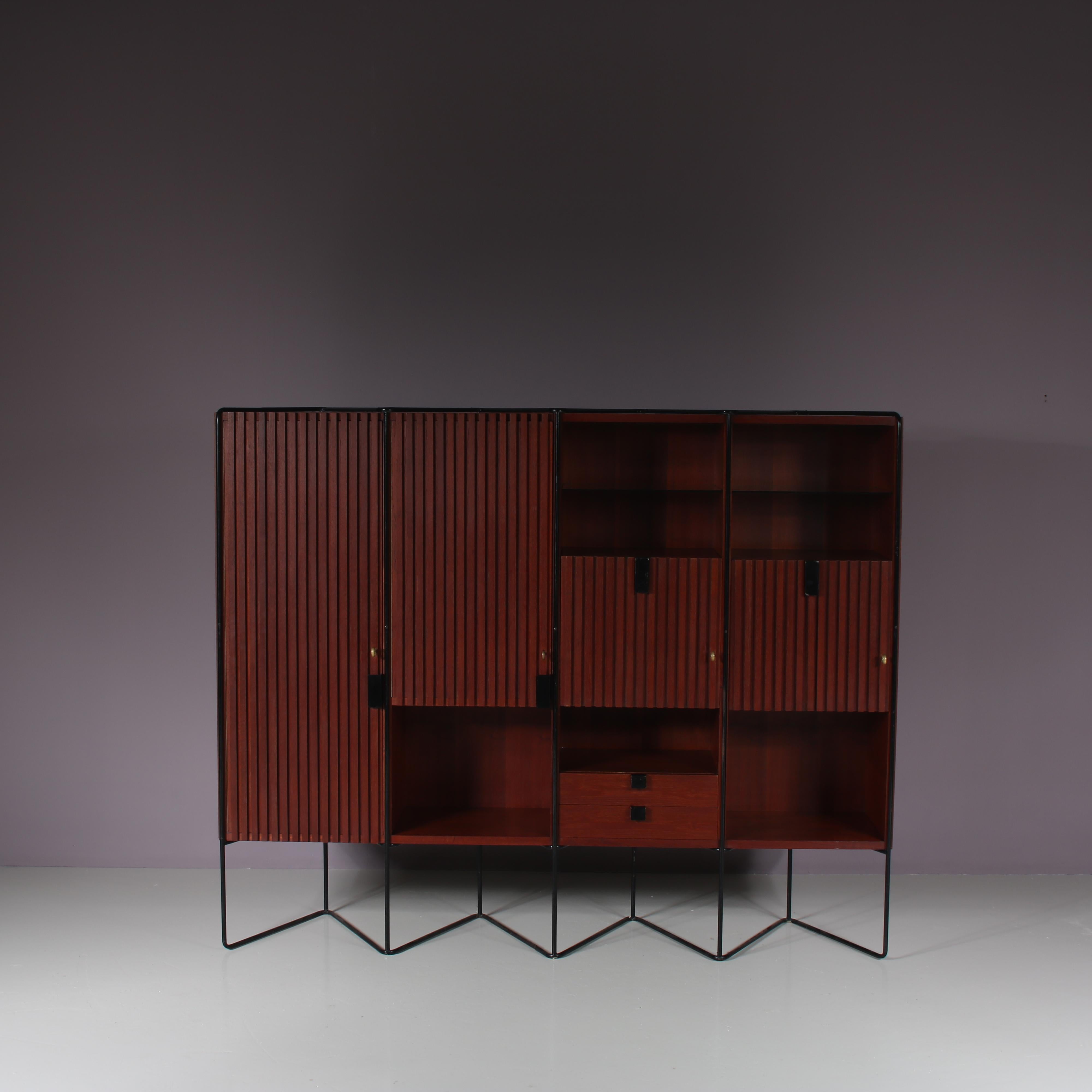 This outstanding cabinet is a design by Taichiro Nakai, manufactured by La Permanente Mobili in Italy around 1960.

Made of high quality teak wood in a warm brown colour on a thin, tubular black metal base. The finish of the many elements is truly